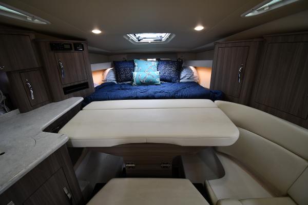 2021 Regal 35 Sport Coupe interior with cozy bed, dining area, and modern cabinetry.