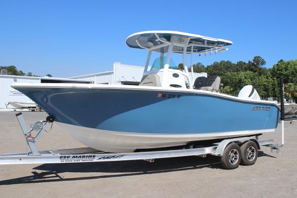 2023 Sea Pro 239 Center Console boat on trailer, blue hull, outdoor setting.
