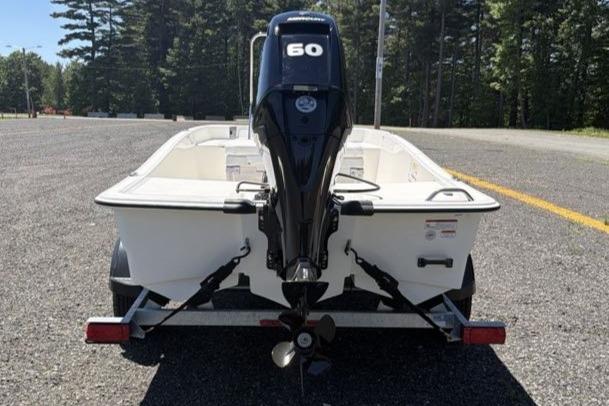 2026 Mako Pro Skiff 15 CC boat with 60 HP engine on trailer.