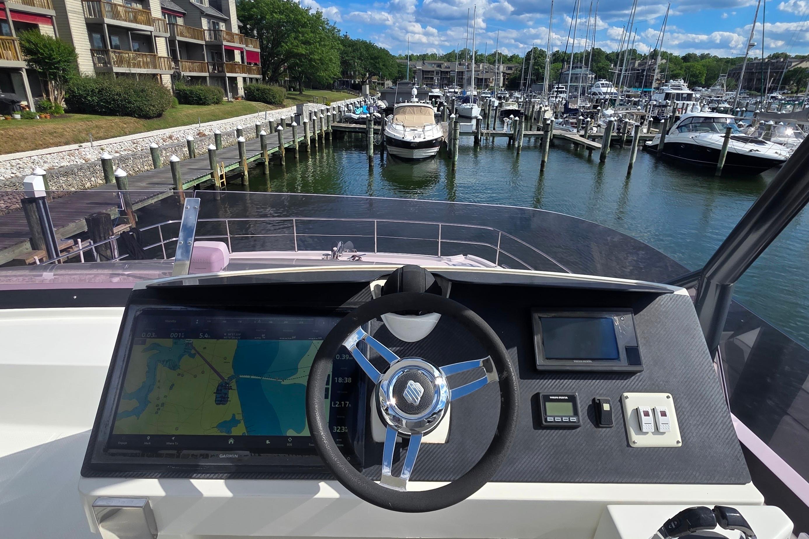 Helm of 2018 Fountaine Pajot Motor Yacht 44 overlooking marina with docked boats.