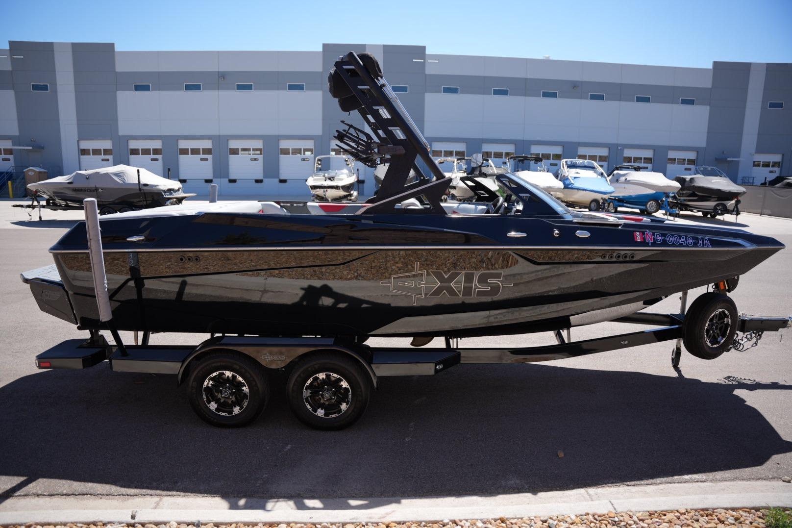 2019 Axis A22 boat on trailer, parked in marina lot with other boats.