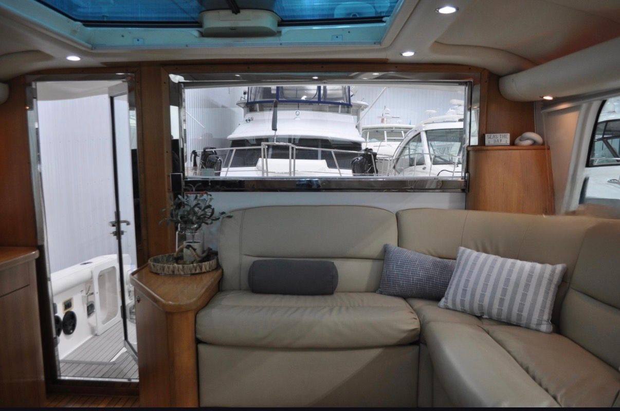 Interior of a 2005 Tiara Yachts 5200 Sovran with beige sofa and wooden furnishings.