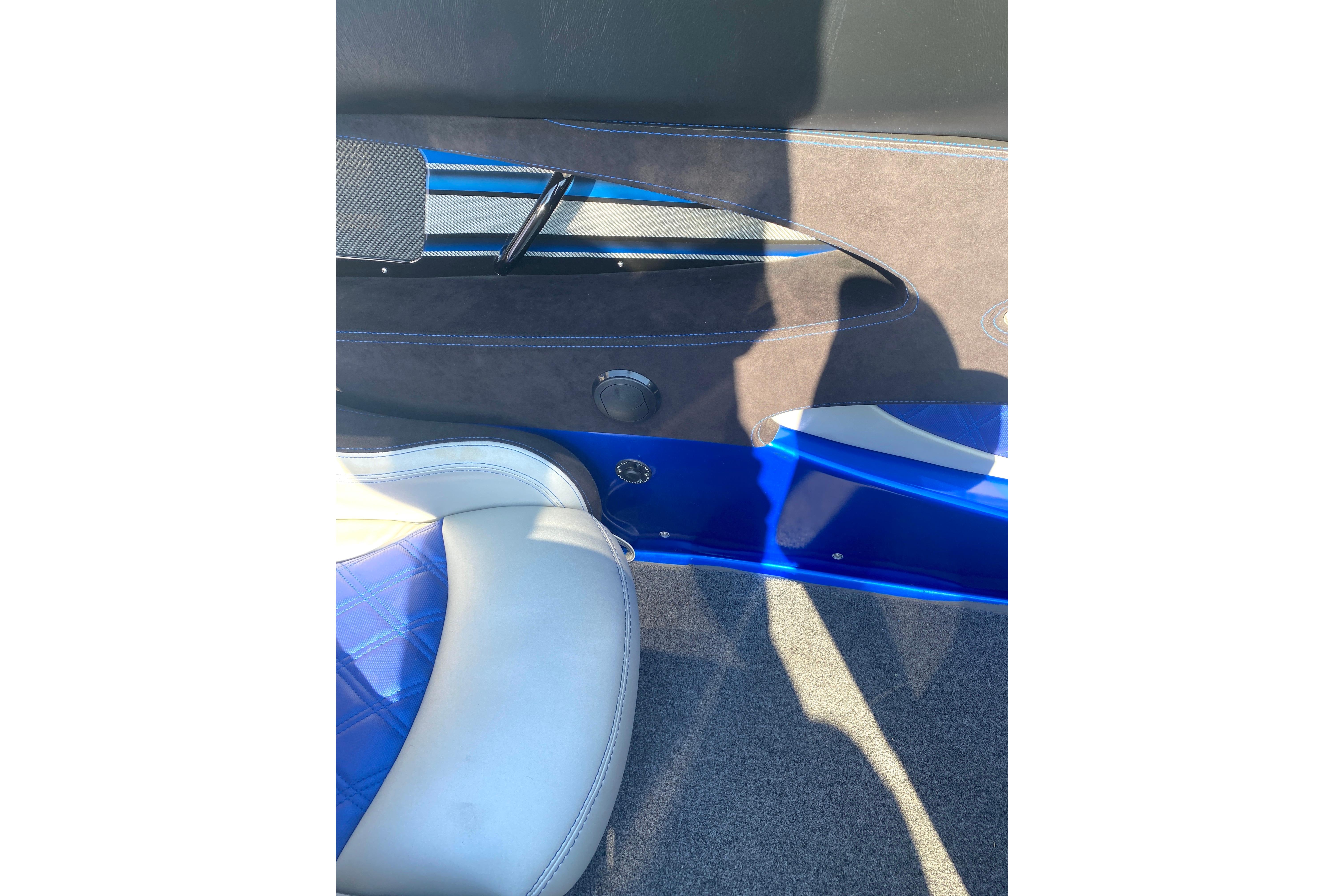 Interior of 2016 MTI 44 RP boat, featuring blue and white seating with carbon fiber accents.