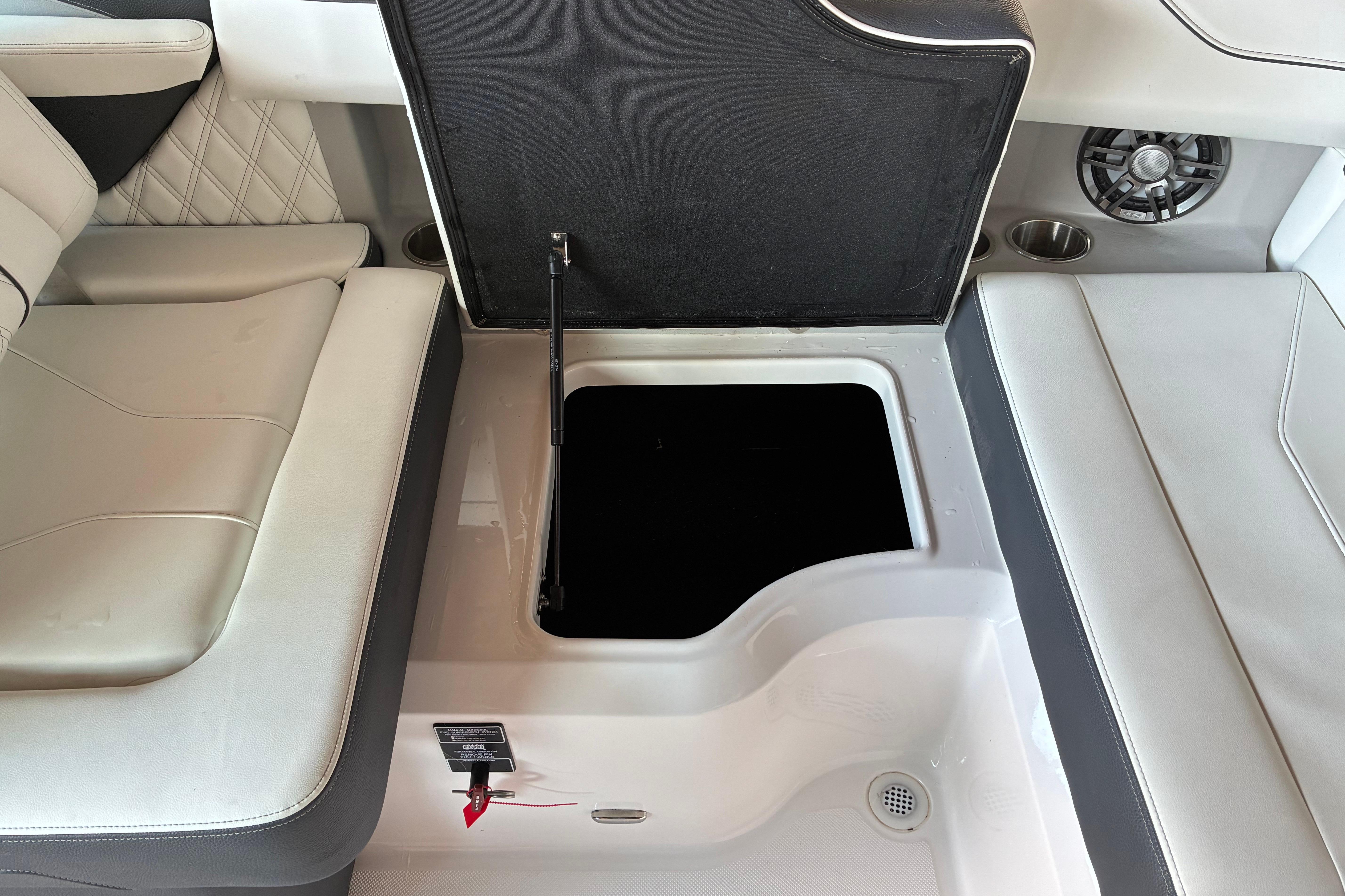 2025 Regal LS2 boat interior storage compartment with open lid, featuring cushioned seating.