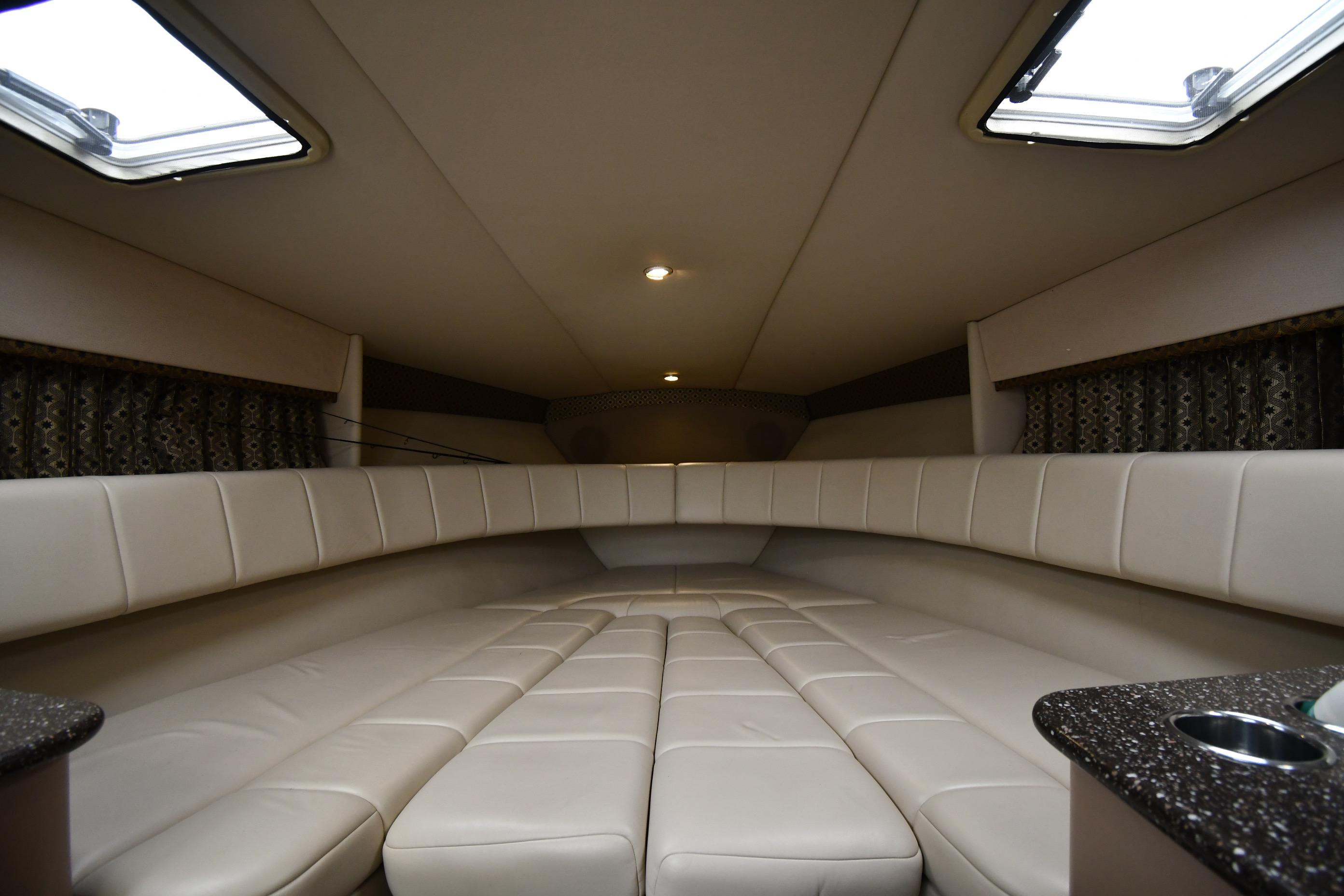 2004 Formula 330 Sun Sport cabin interior with beige seating and overhead lighting.