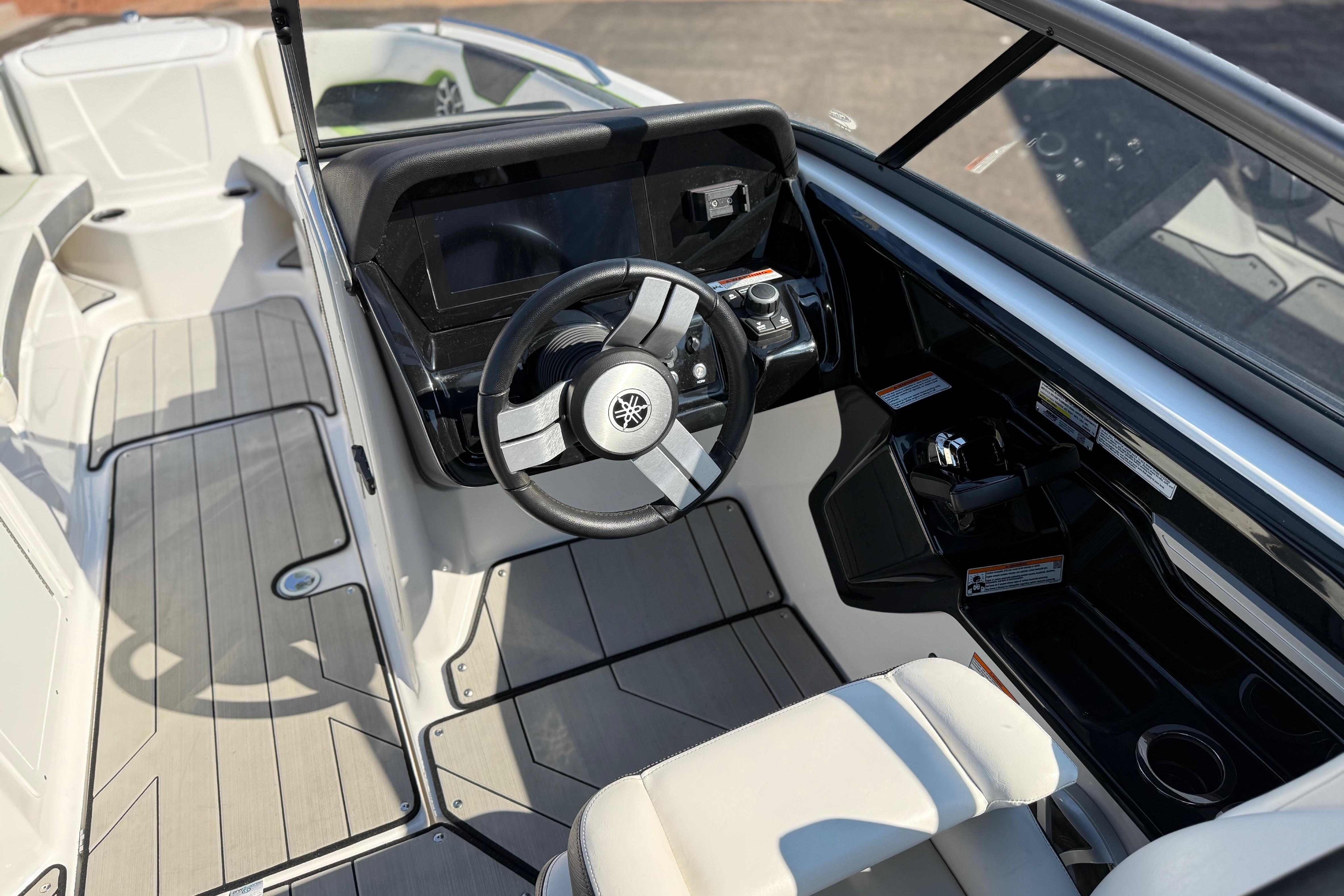 2022 Yamaha Boats 212XE cockpit with sleek steering wheel and modern dashboard design.