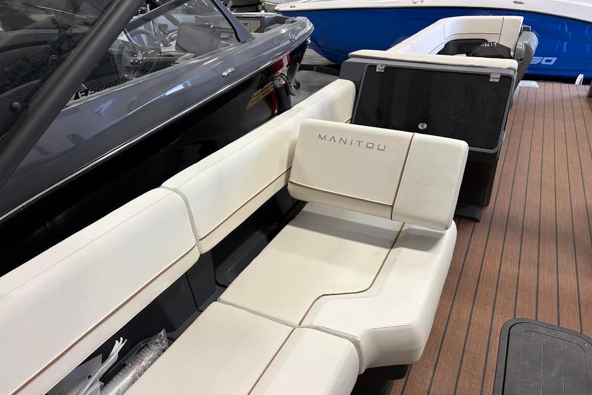 2023 Manitou EXPLORE 26 SHP 575 boat interior with white seating and wood flooring.