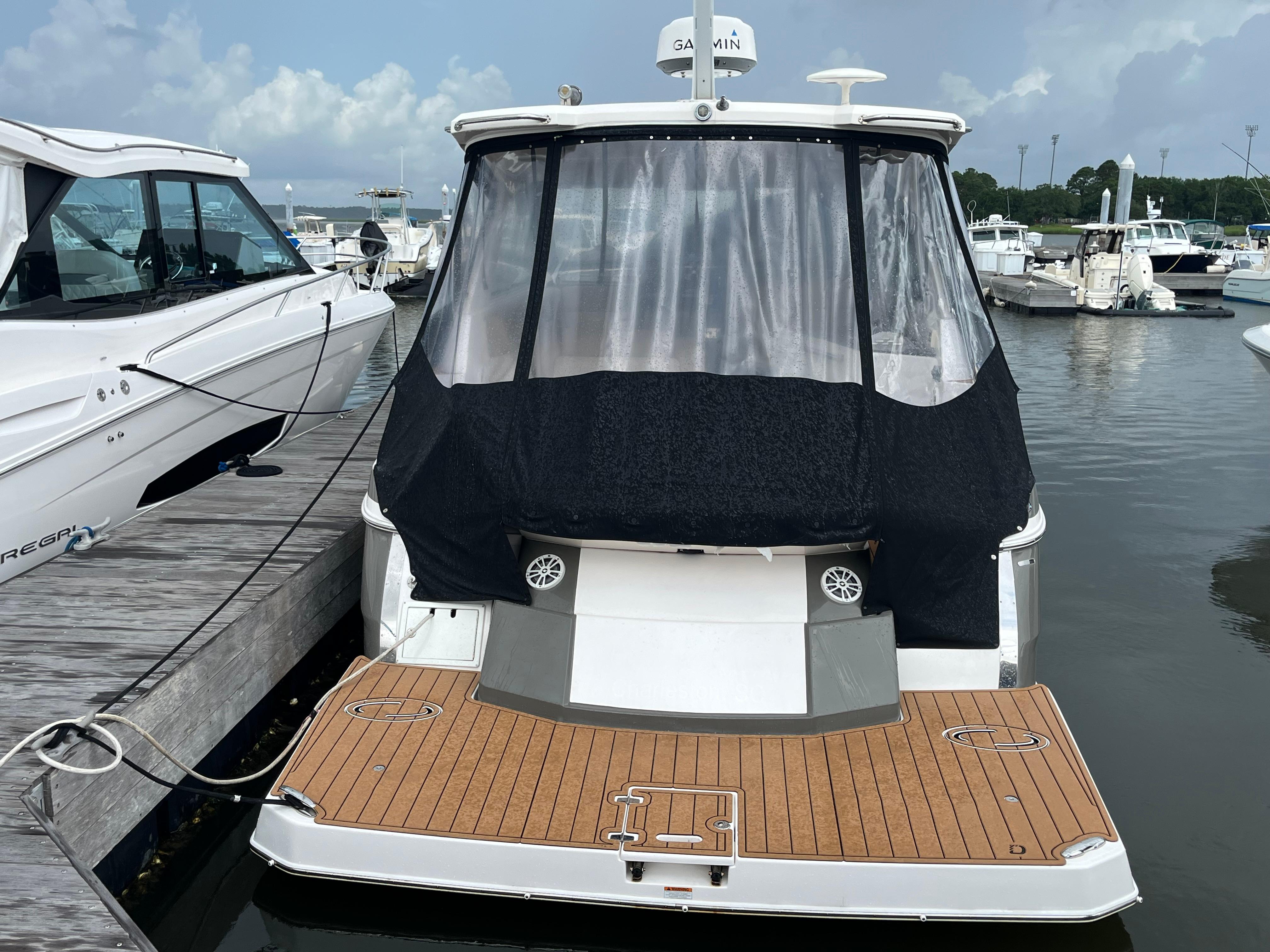 2014 Regal 35 Sport Coupe docked at marina, rear view with covered deck.