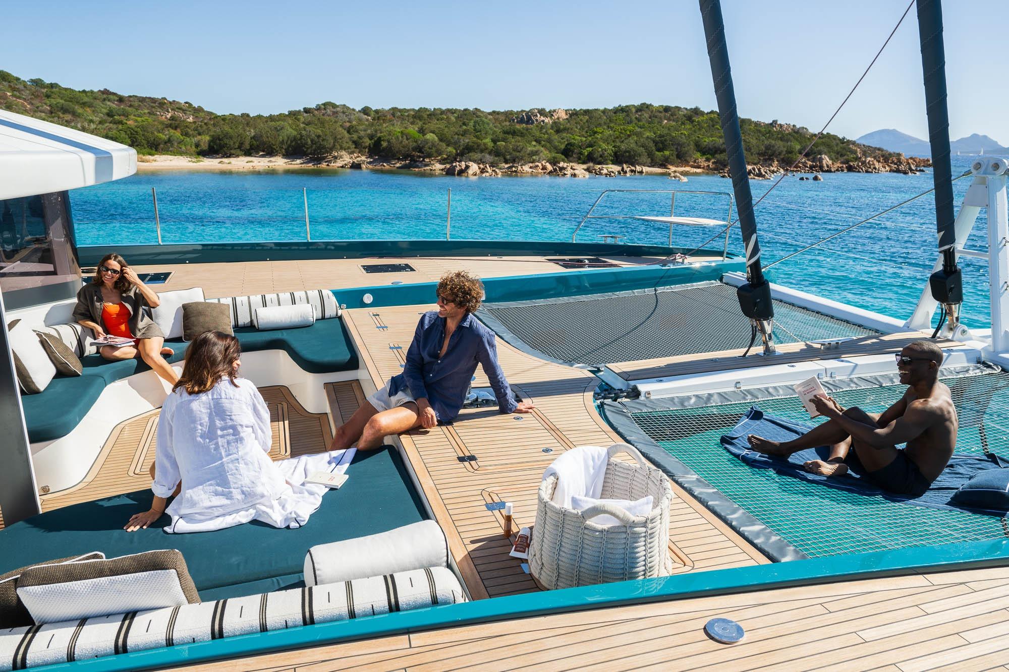 People relaxing on a 2026 Lagoon Eighty 2 yacht, enjoying the sun and sea views.
