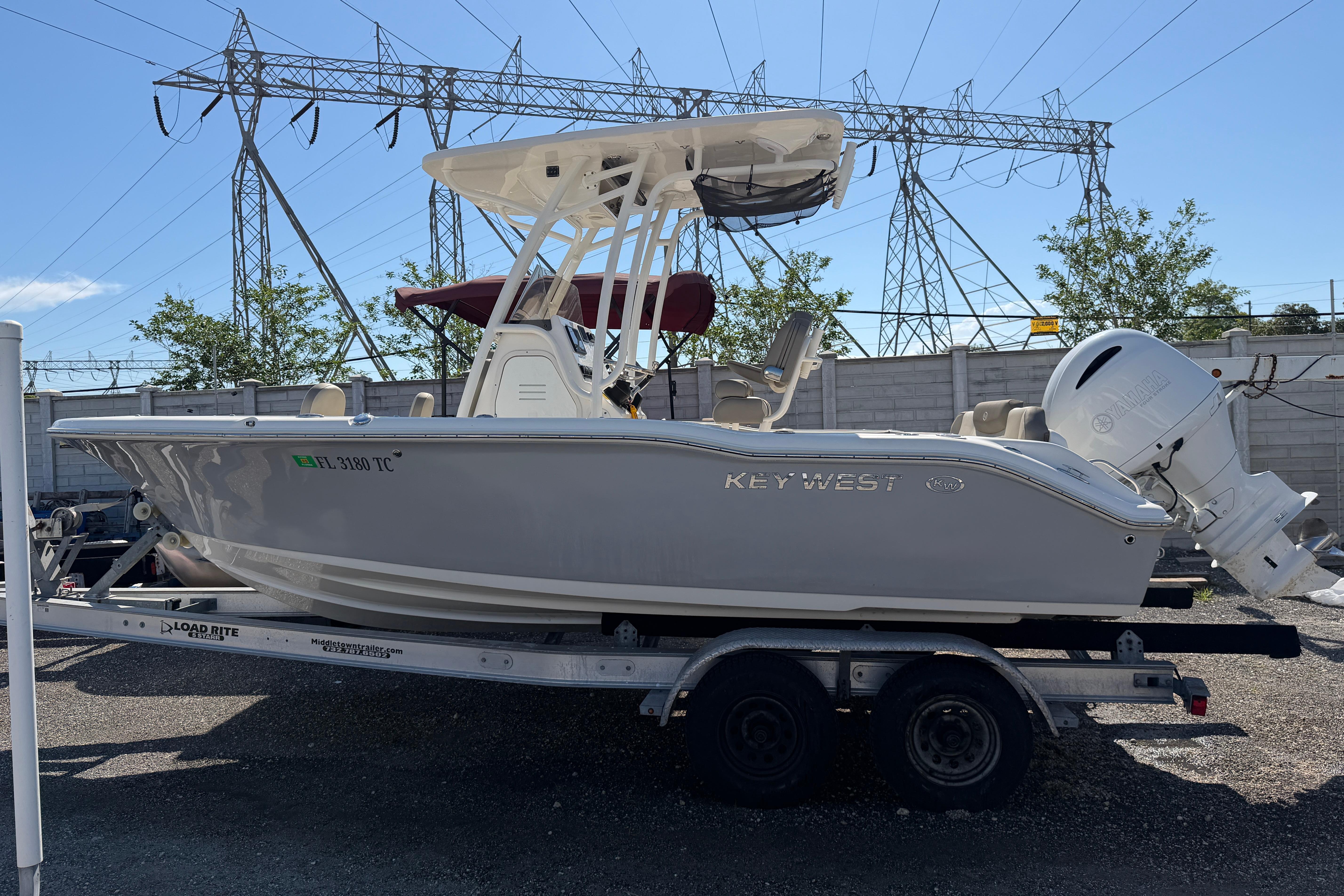 2022 Key West 219 FS boat on trailer, parked outdoors near power lines.