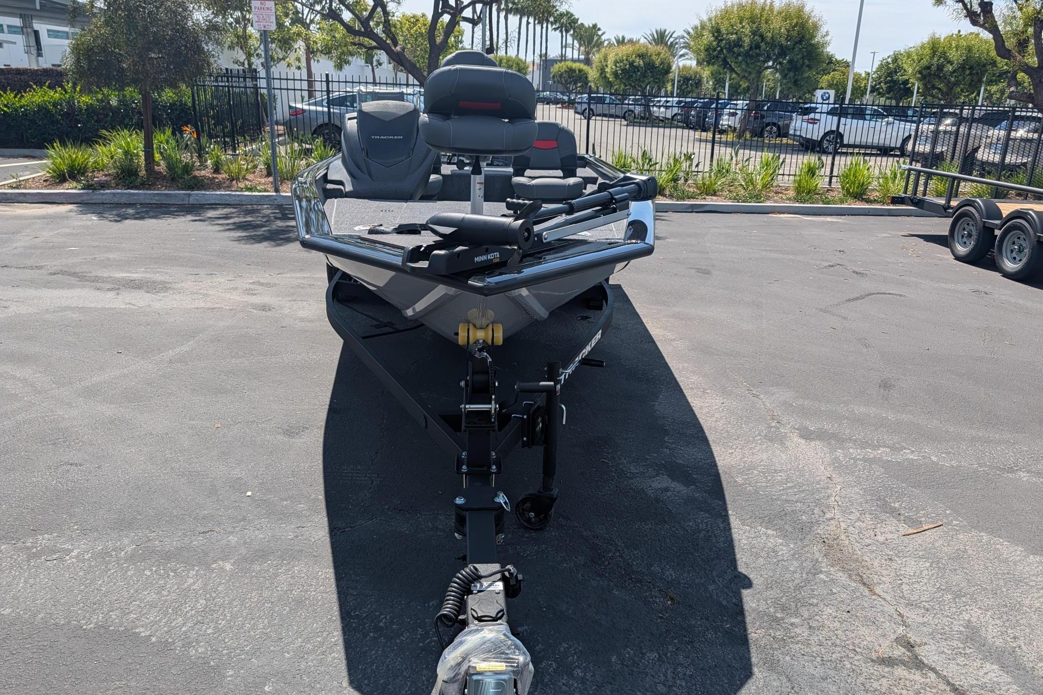 A Tracker Pro Team 175 Crappie Edition boat is on a trailer in a parking lot.