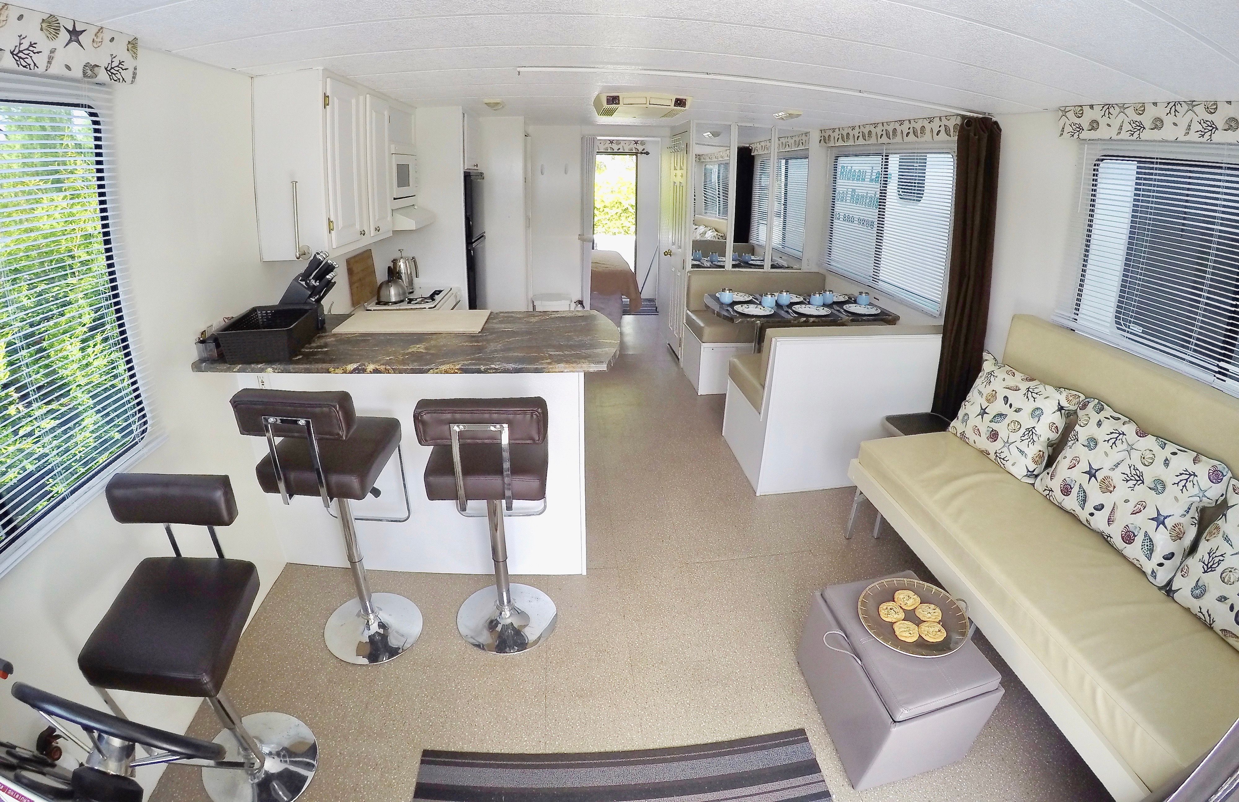 Interior of a 42 ft catamaran with kitchen, bar stools, sofa, and dining table.