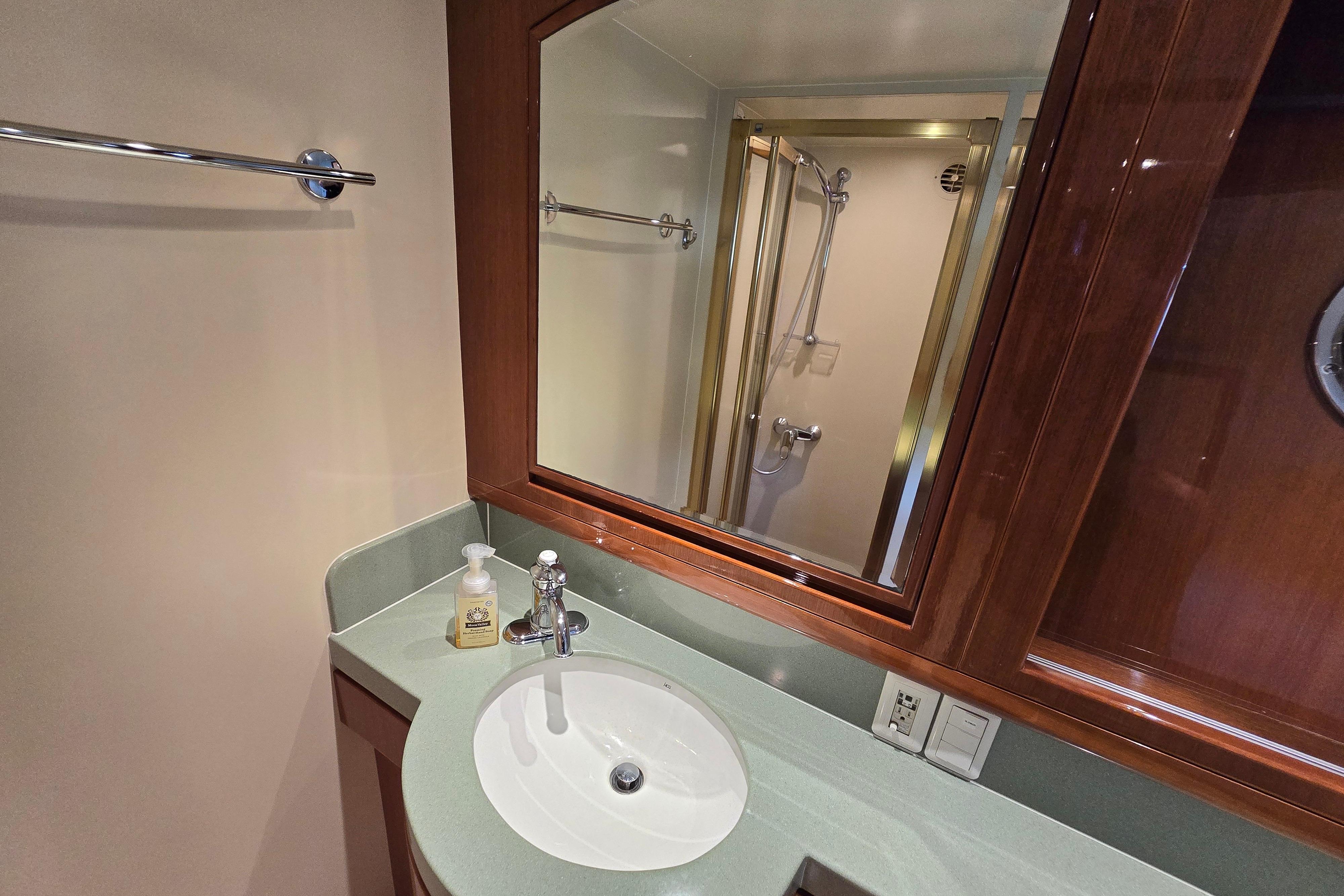 Luxurious bathroom in 2004 Grand Harbour 58 yacht with modern fixtures and elegant wood cabinetry.