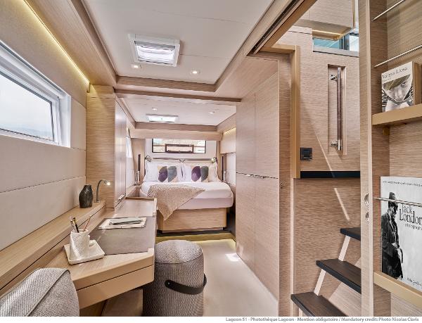 Luxurious interior of 2025 Lagoon 51 ICONIC yacht, featuring modern bedroom and workspace.