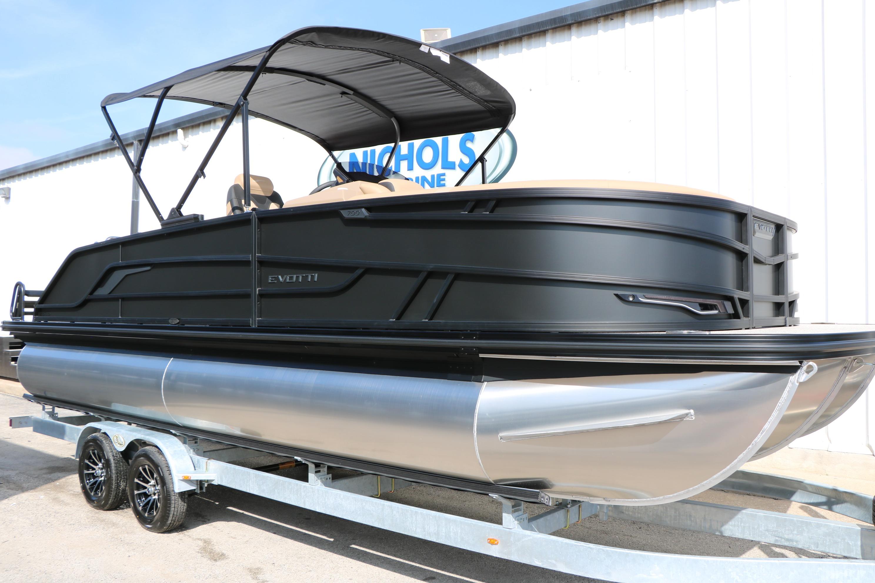 2026 Evotti 723CS pontoon boat on trailer, featuring sleek black design and canopy.