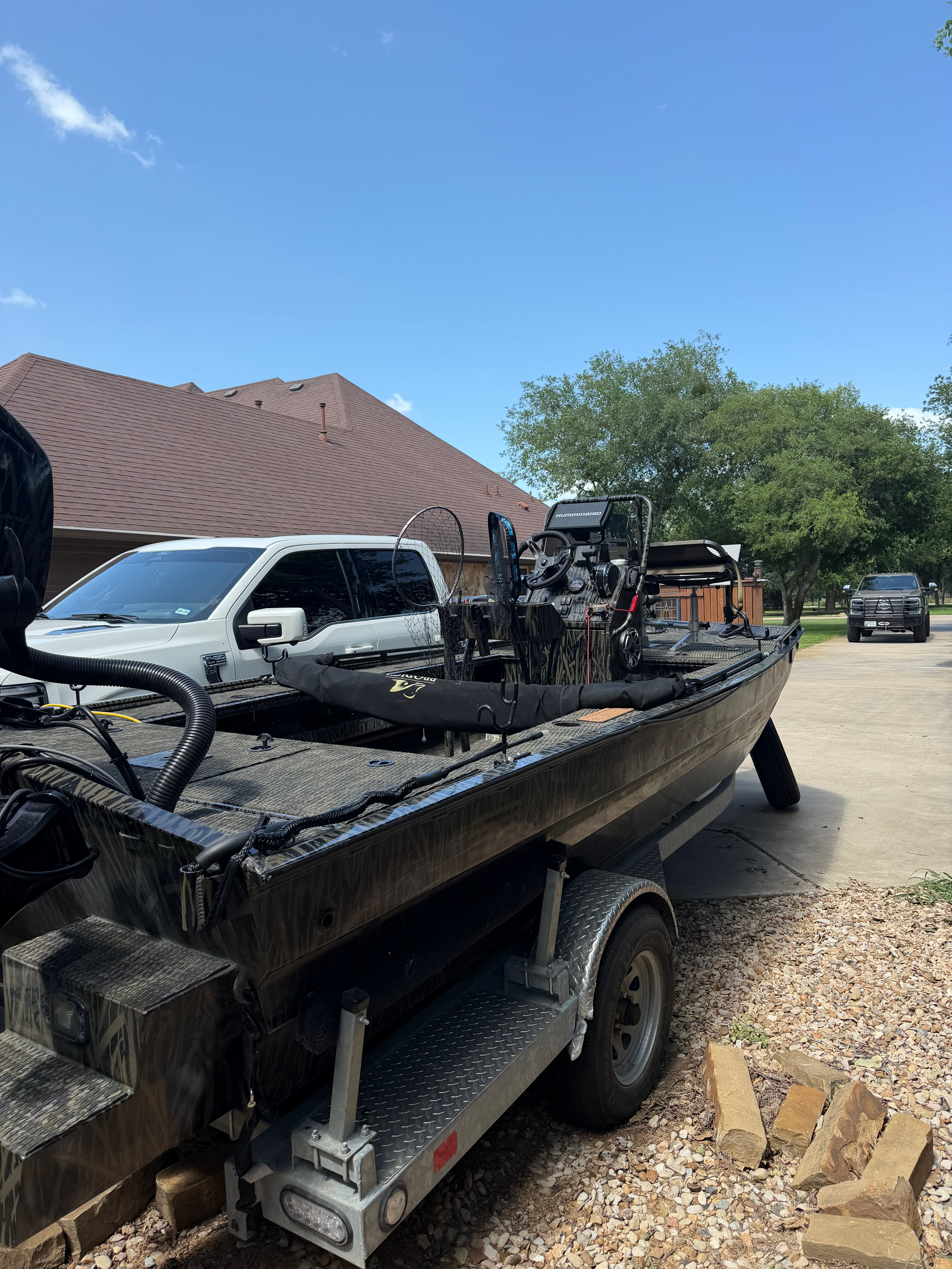 A 2023 Prodigy 1860 boat is on a trailer in a driveway.