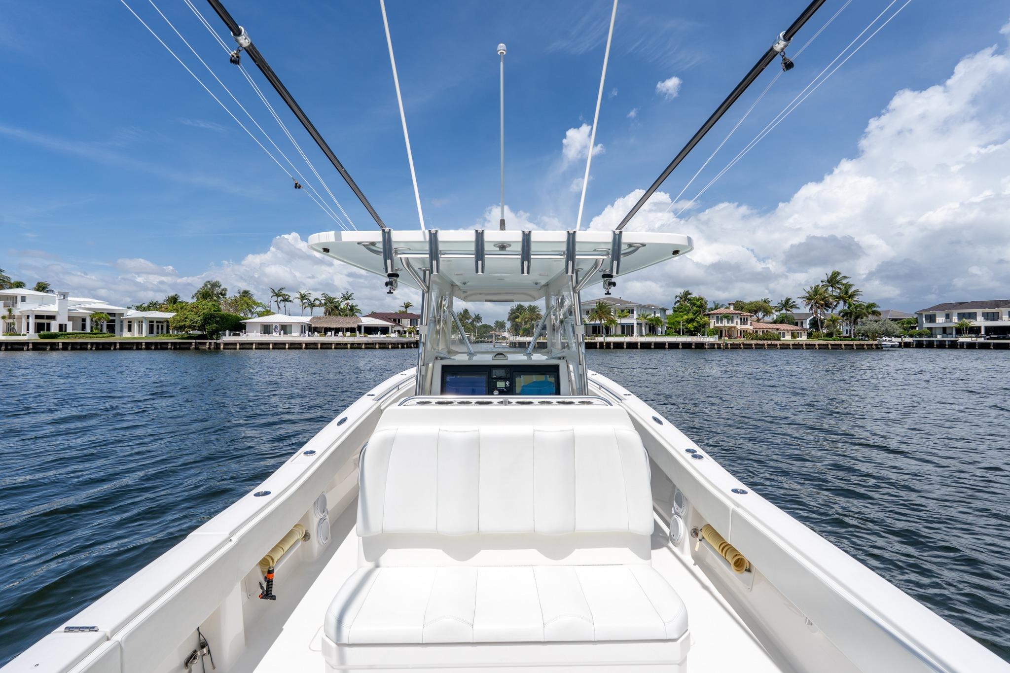 2017 Invincible 39 Open Fisherman boat on calm water, clear sky, luxury waterfront homes.