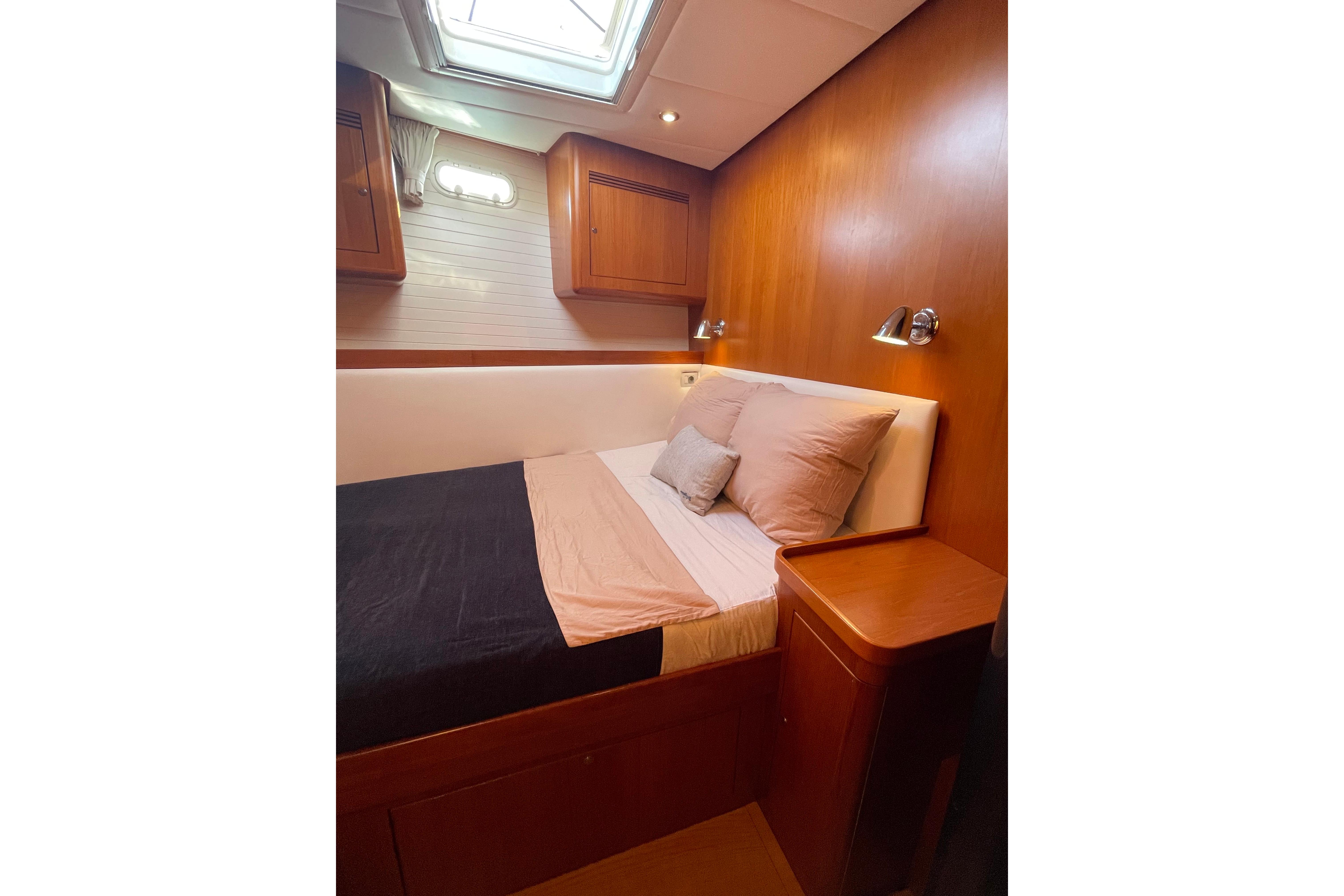 Luxurious cabin interior of 2008 Contest 60/62CS yacht with cozy bed and wooden finish.