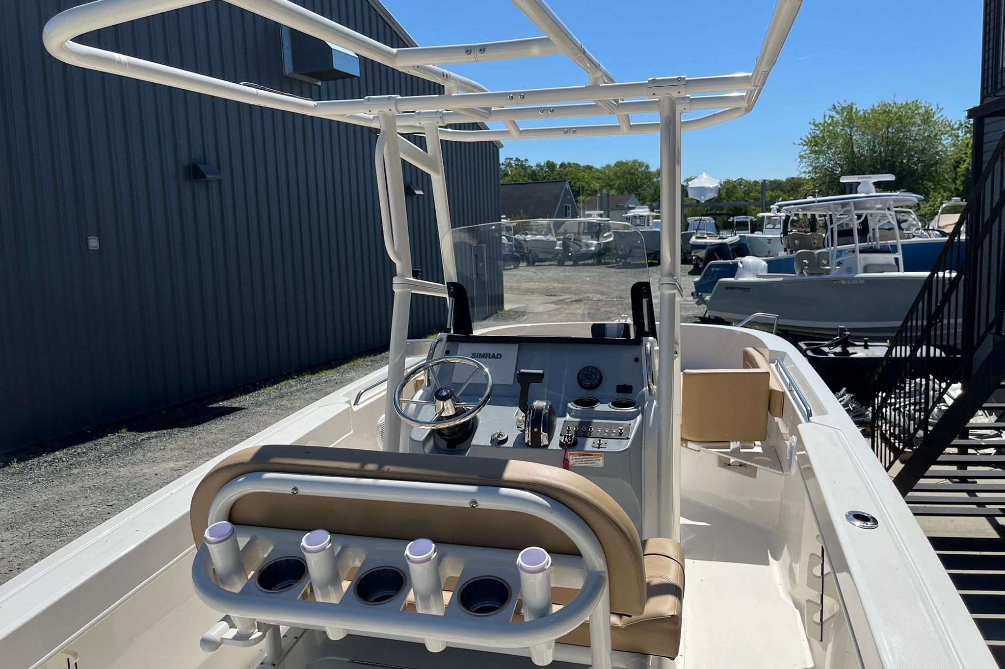 2026 Bayliner Trophy T22CC boat interior with steering console and rod holders.
