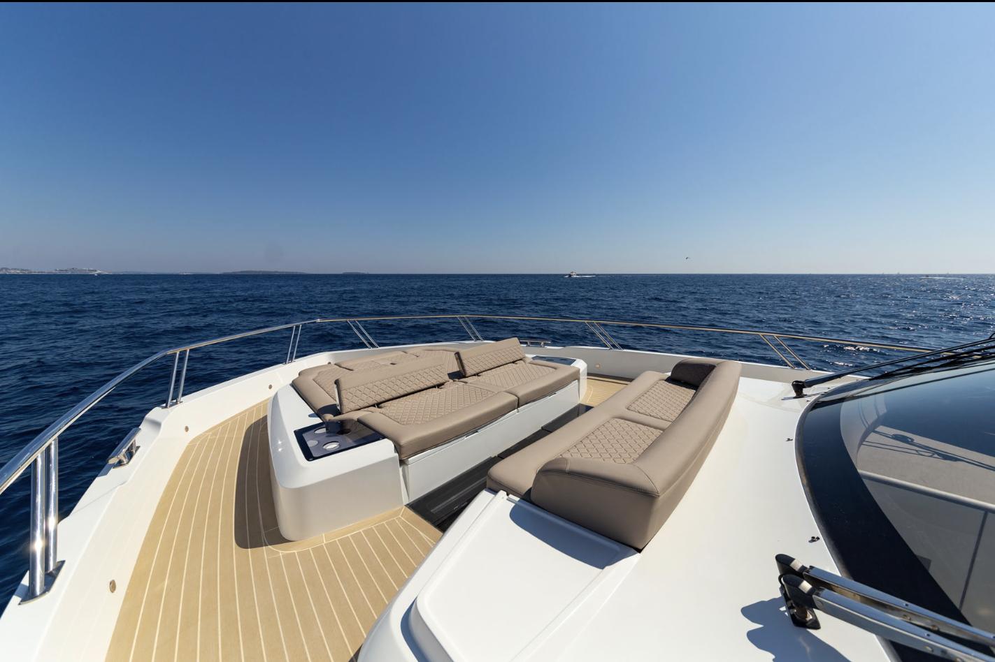 Luxury deck of 2024 Galeon 560 Fly yacht with sun loungers and ocean view.
