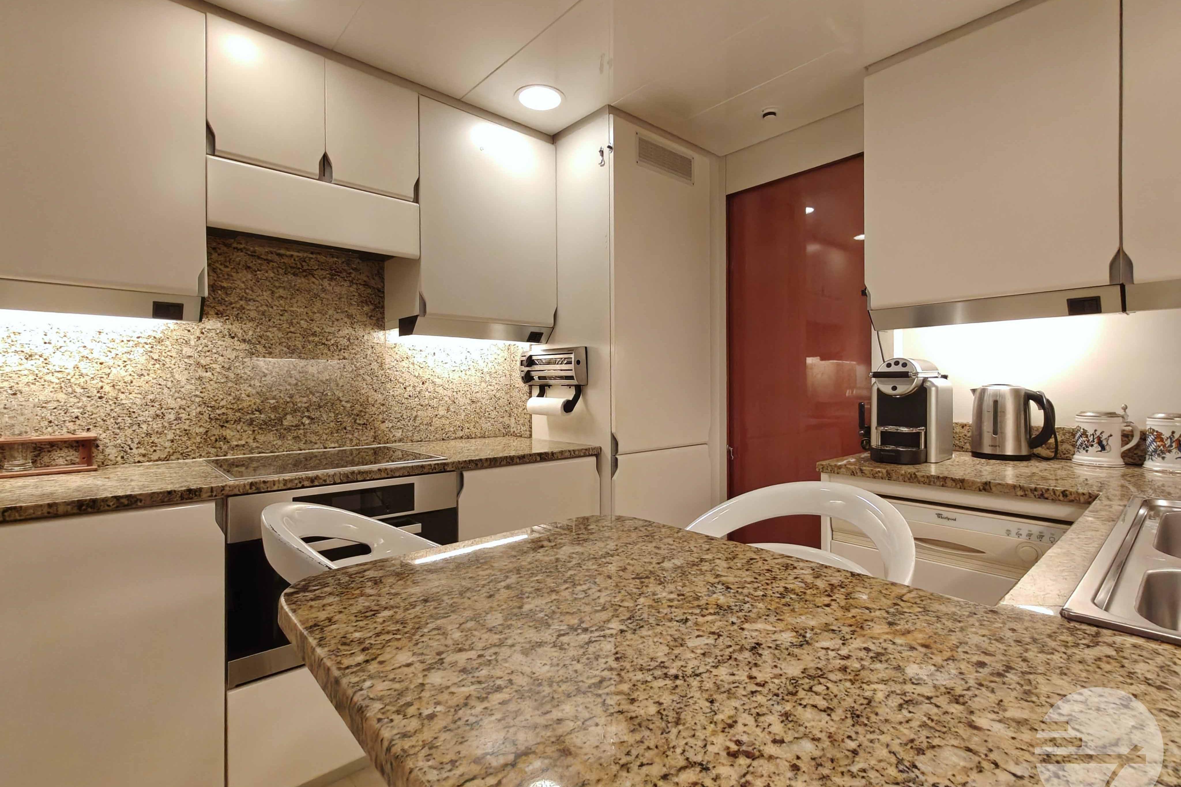 Luxurious kitchen interior on 1999 Sanlorenzo SL82 yacht with granite countertops and modern appliances.