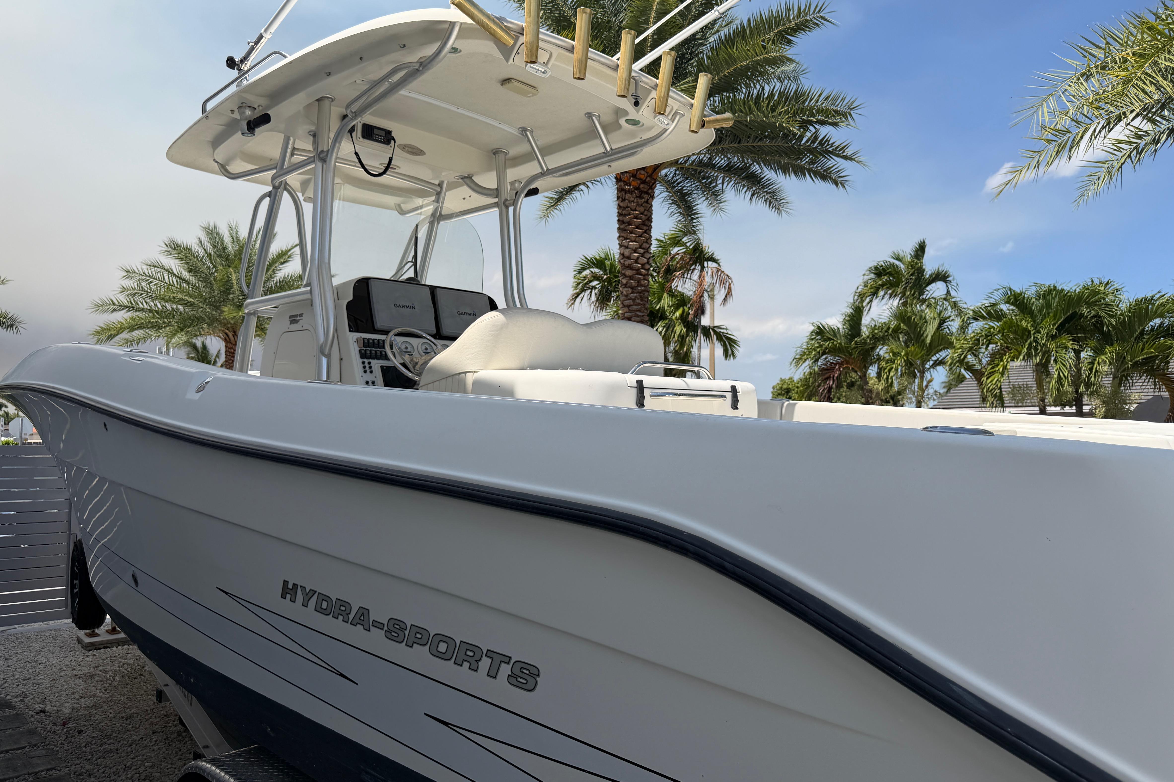 2008 Hydra-Sports Vector 2900 CC boat docked, surrounded by palm trees under a clear sky.