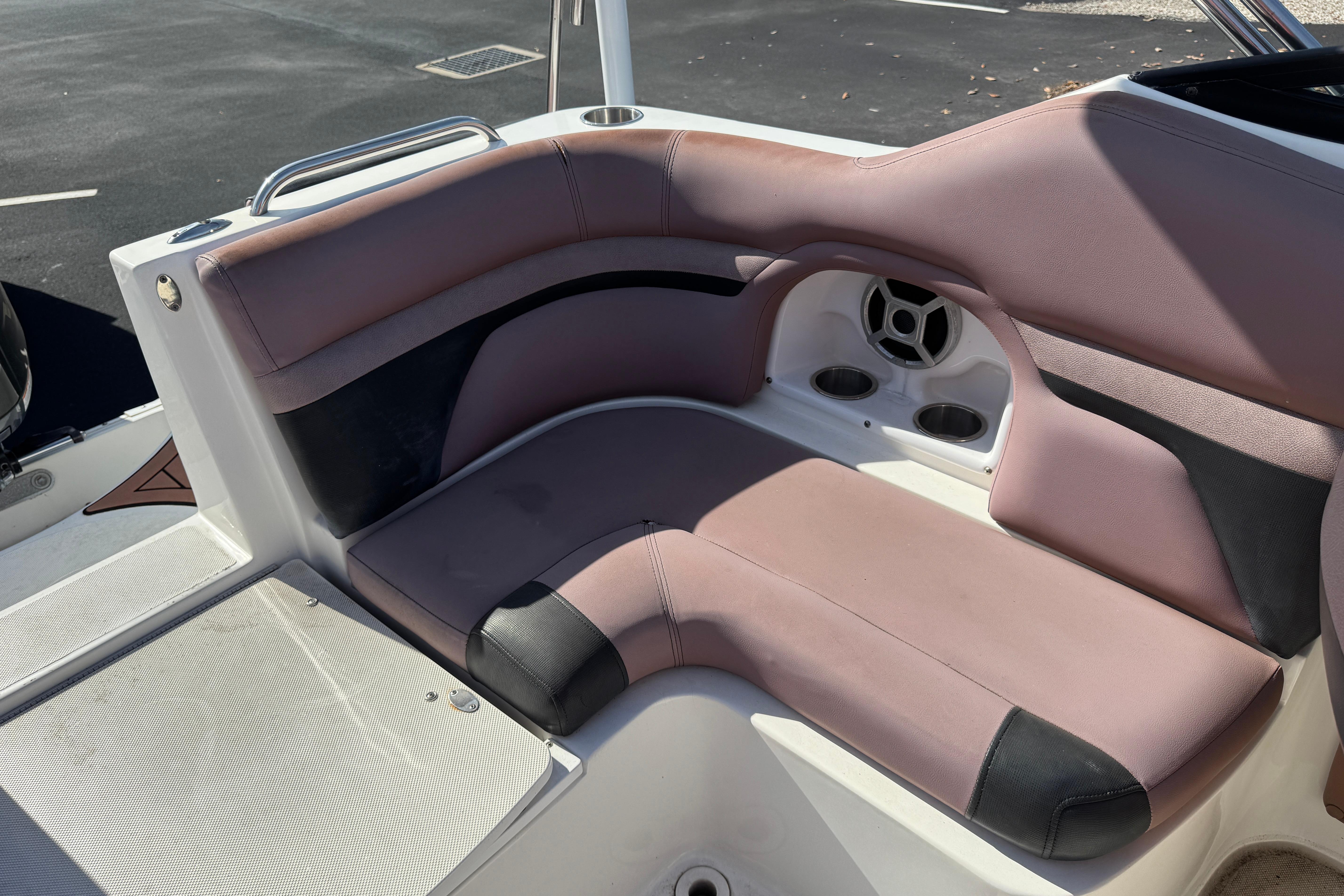 2018 Hurricane SunDeck 2400 OB boat seating area with cup holders and speaker.