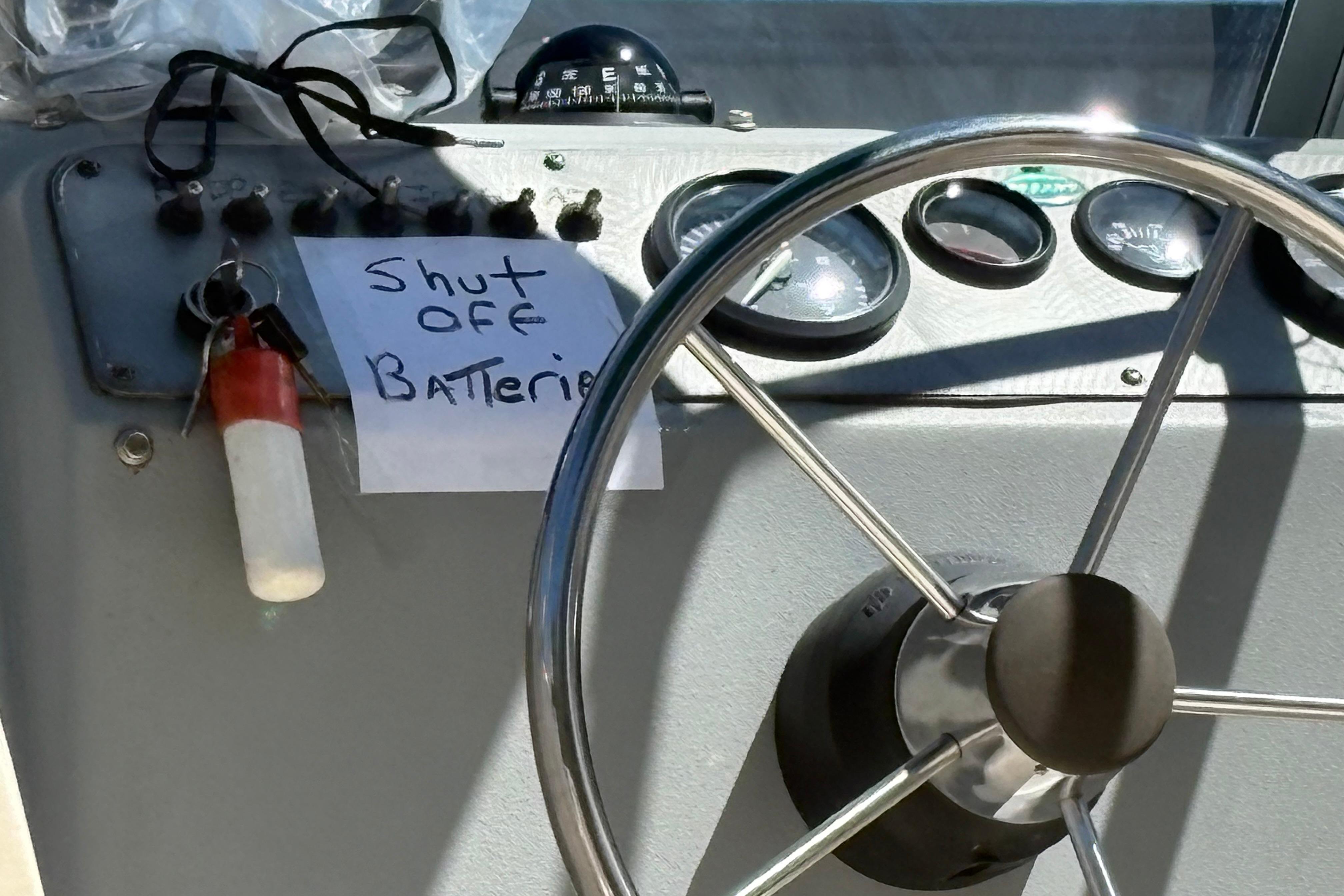 2004 Trophy 1802 Walkaround boat dashboard with steering wheel and battery shut-off note.