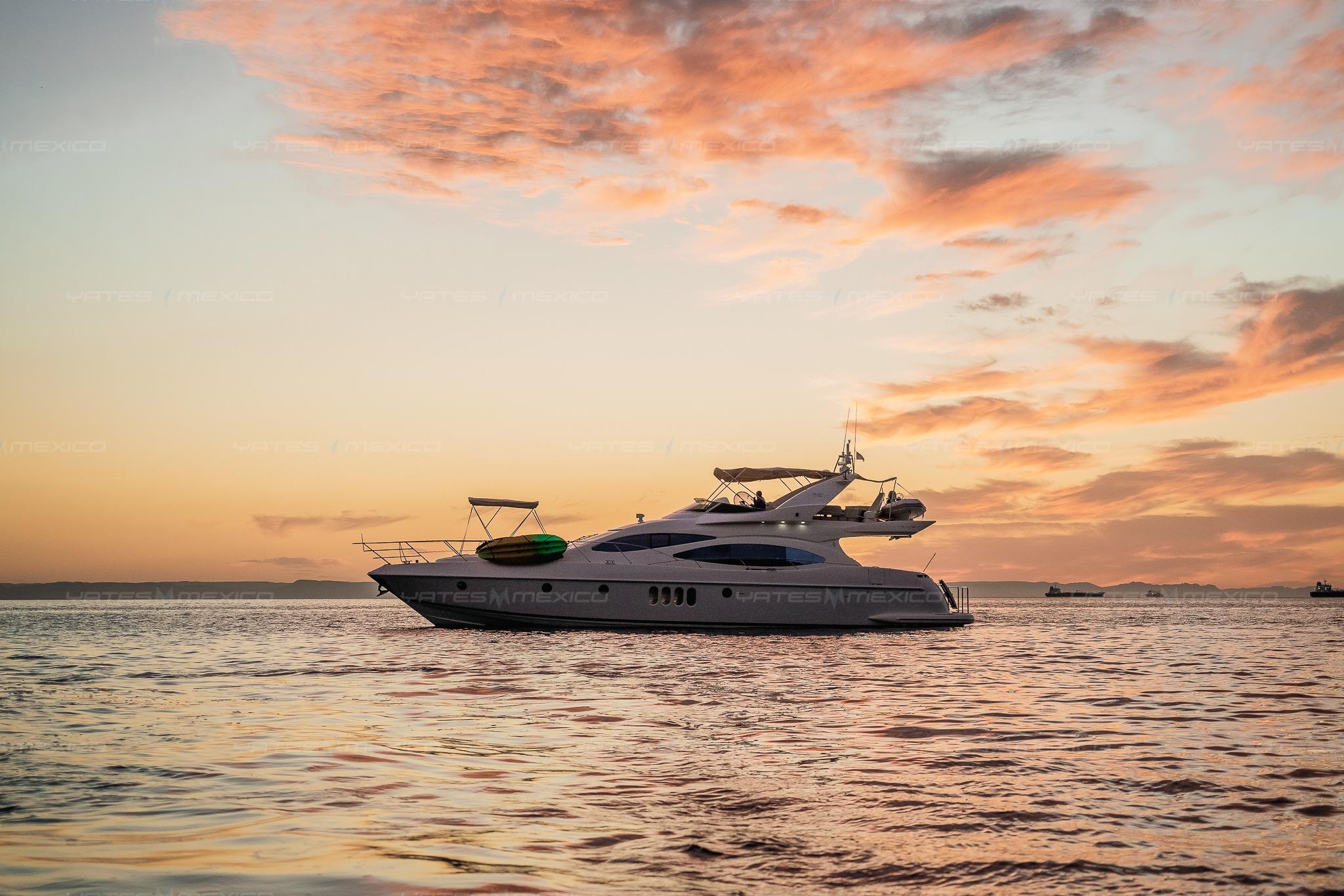 Luxury Azimut 68 Plus yacht at sunset, 2004 model, on tranquil waters.