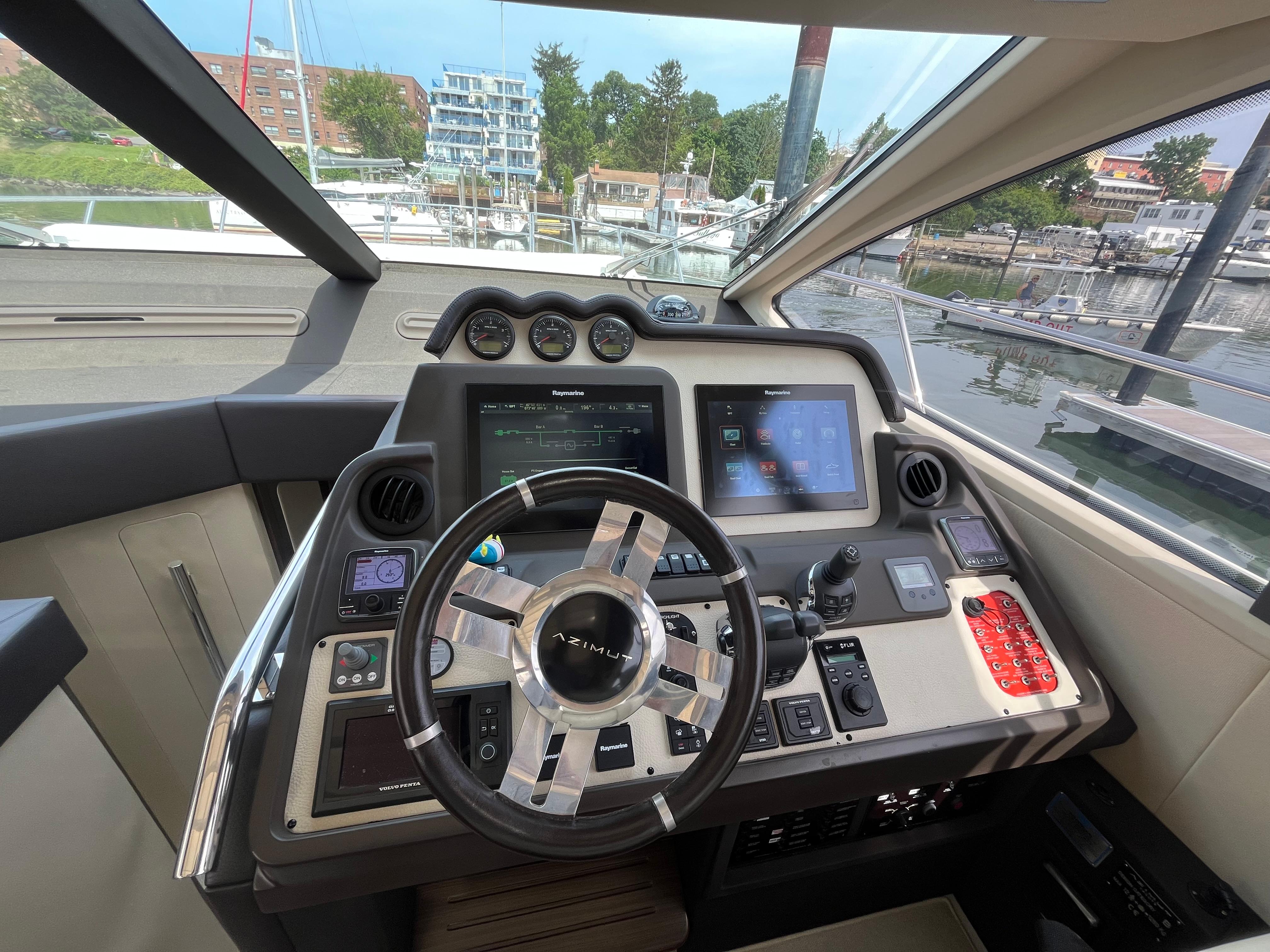 Cockpit of 2014 Azimut 55S yacht with advanced navigation controls and steering wheel.