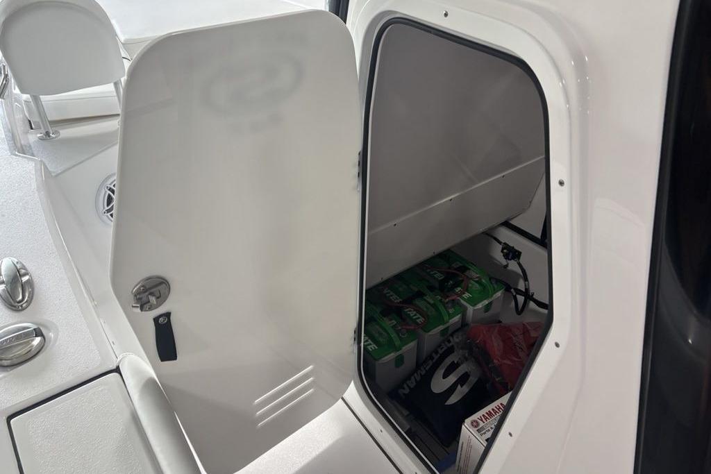 Open storage compartment on 2026 Sportsman Masters 247 Bay Boat, showing interior contents.