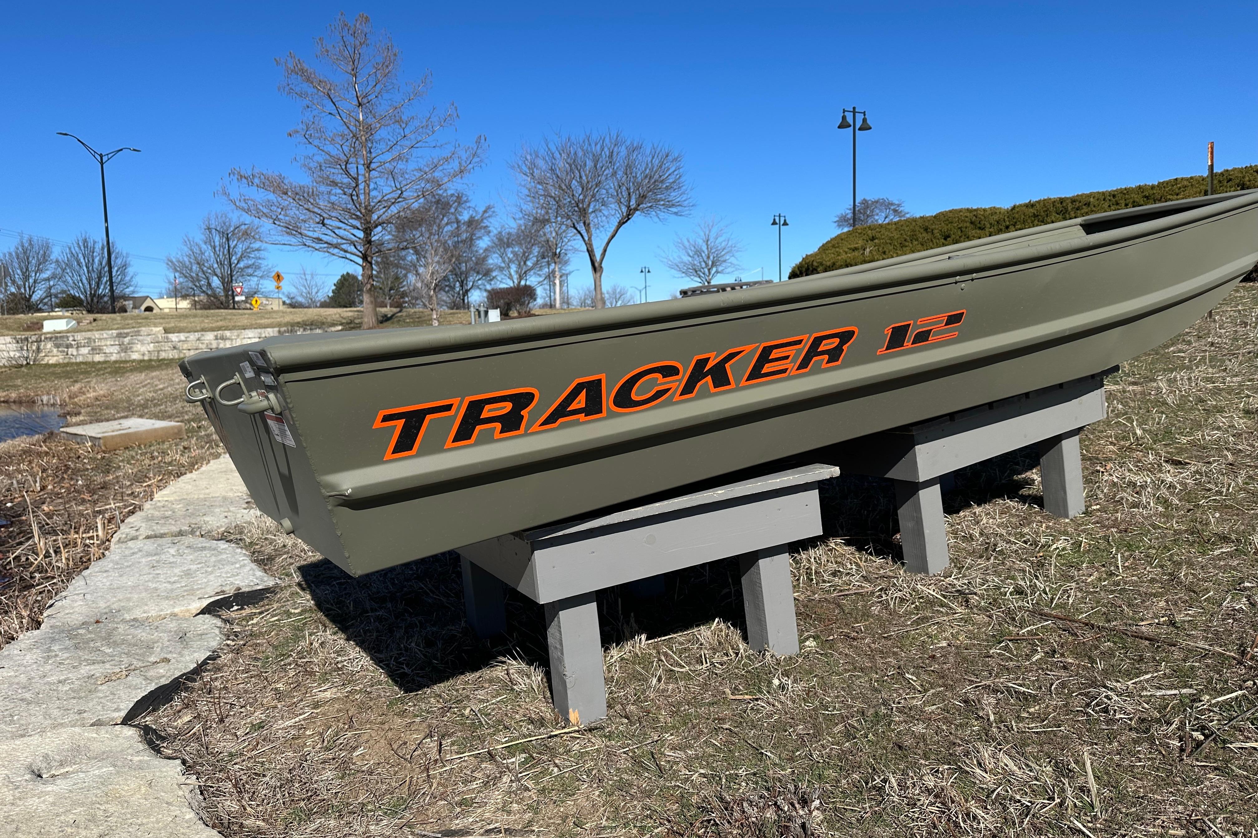 2026 Tracker Grizzly 12 Jon boat displayed outdoors on wooden supports.