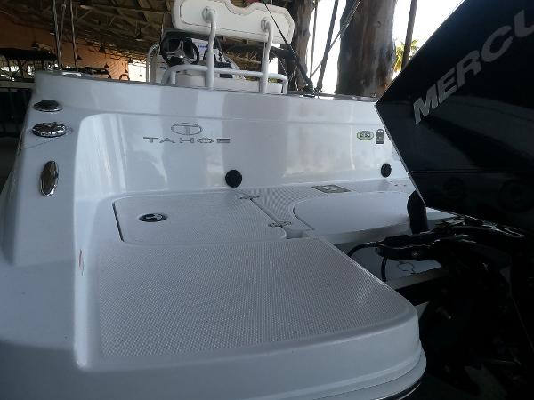 2023 Tahoe 2150 CC boat with Mercury engine, rear view in a covered dock.