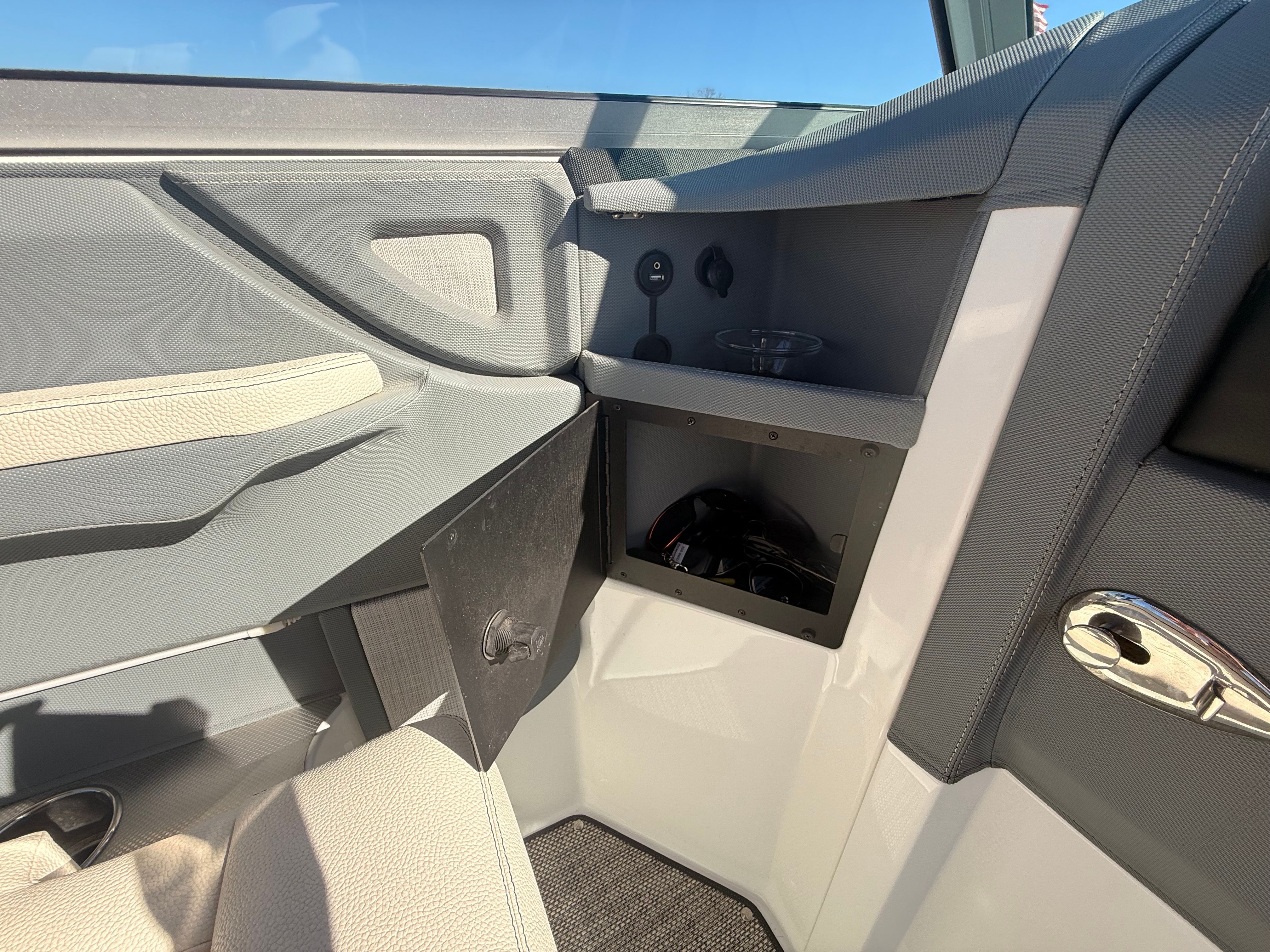 Interior view of a 2019 Cobalt R7 Surf with gray and beige upholstery and storage space.