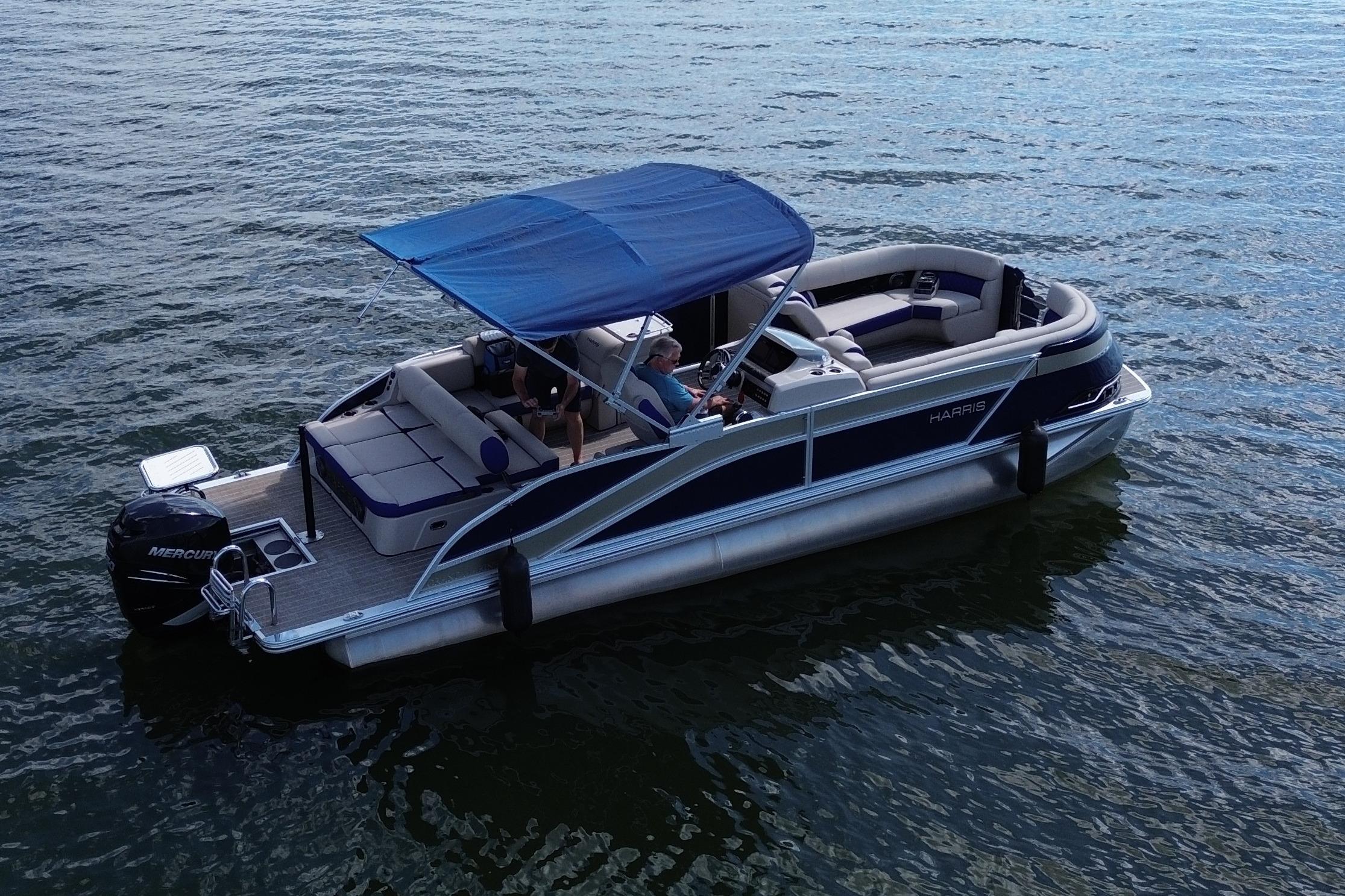 2022 Harris Grand Mariner 250 pontoon boat on water with blue canopy.