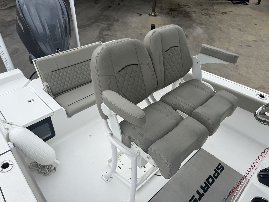 Two cushioned seats on a boat with gray upholstery and armrests.