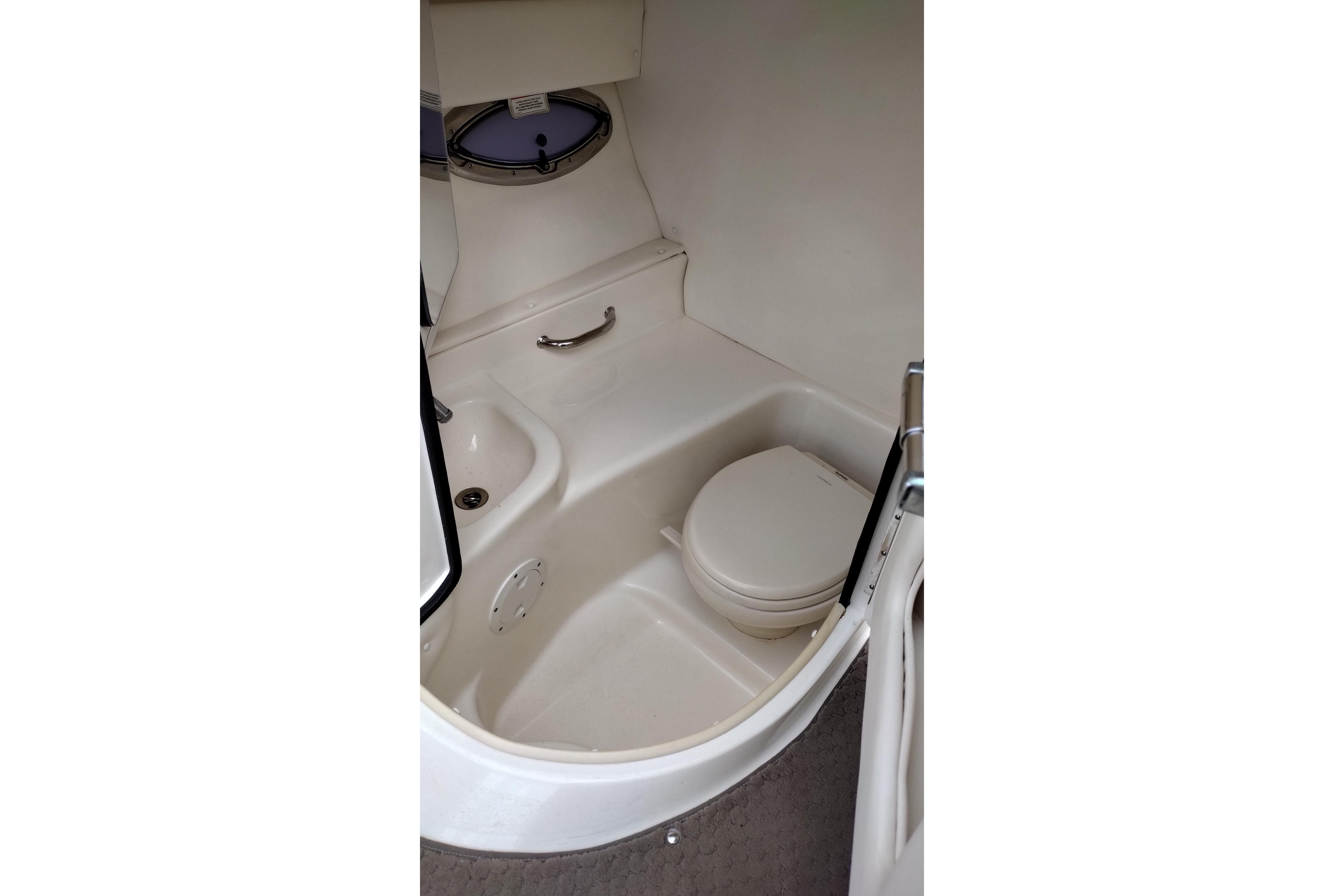 Interior of 2013 Sea Ray 300 SLX boat featuring a compact marine toilet.