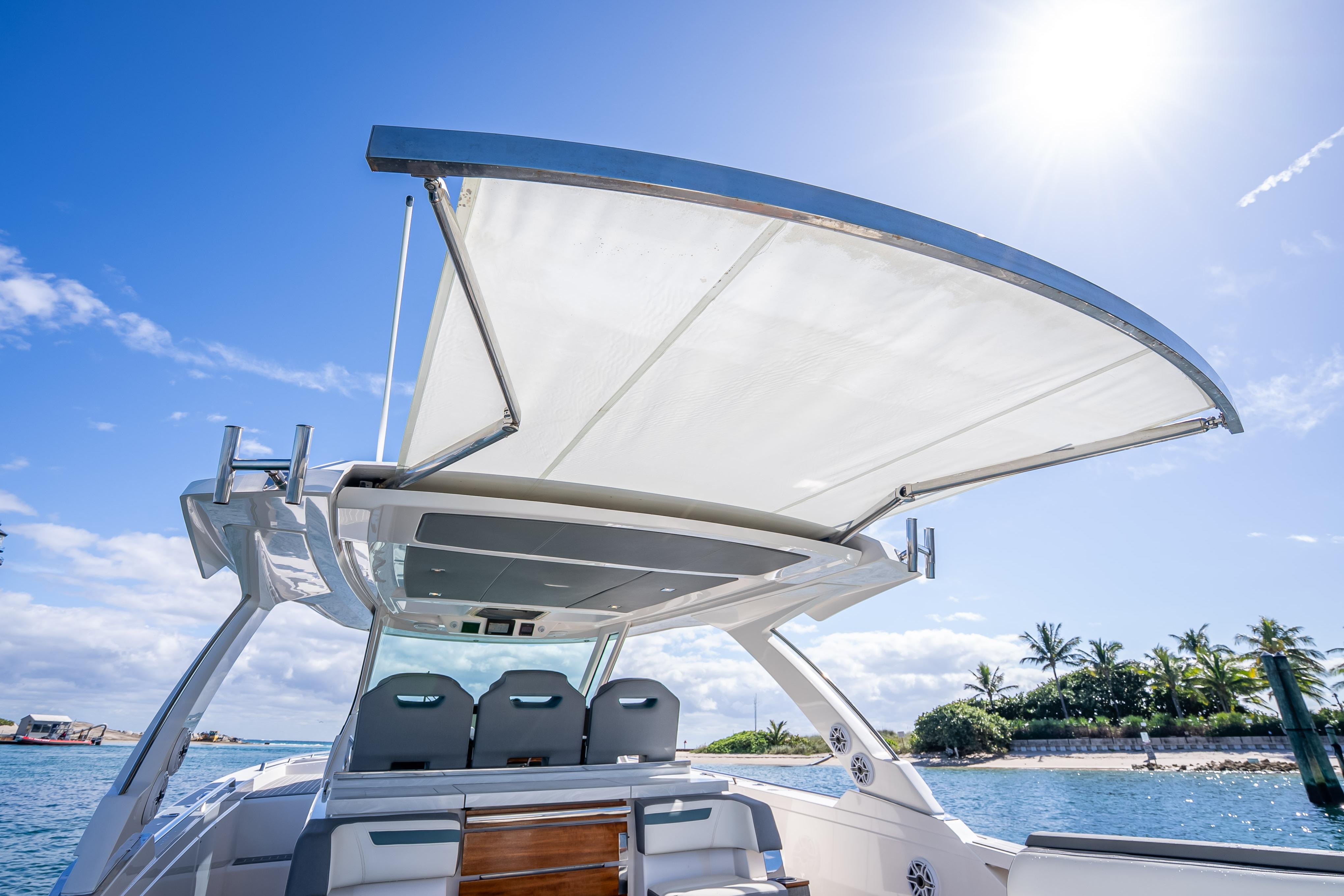 2019 Tiara Sport 38 LS boat with sunshade, ocean view, and clear blue sky.