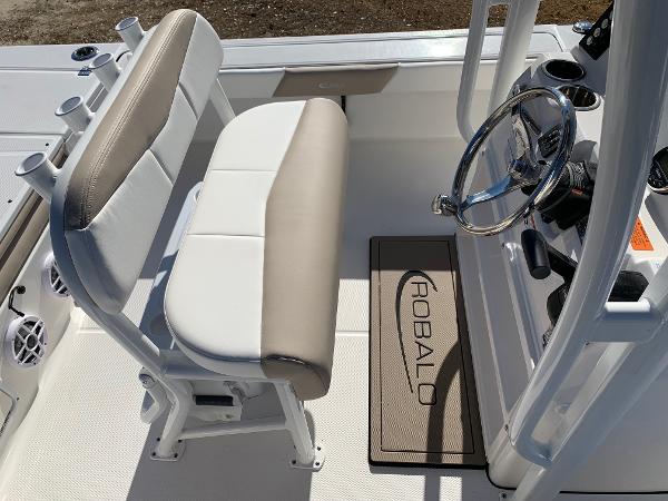 2024 Robalo 226 Cayman boat interior with beige and white seating and steering console.