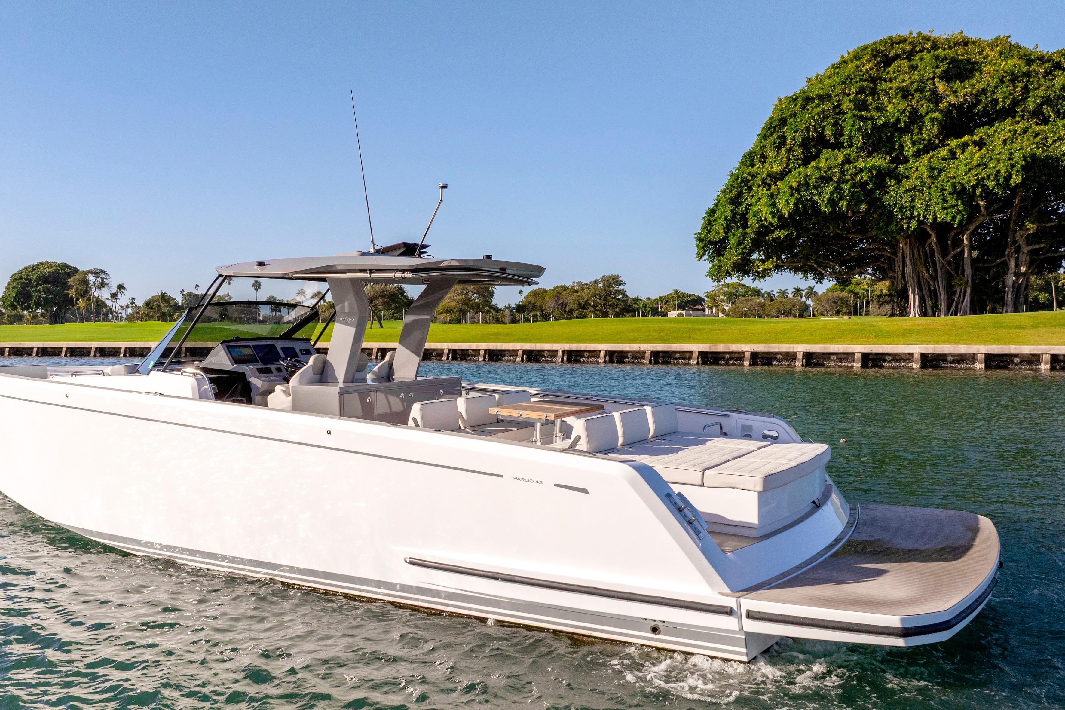 2024 Pardo Yachts P43 cruising on a sunny day near lush greenery.