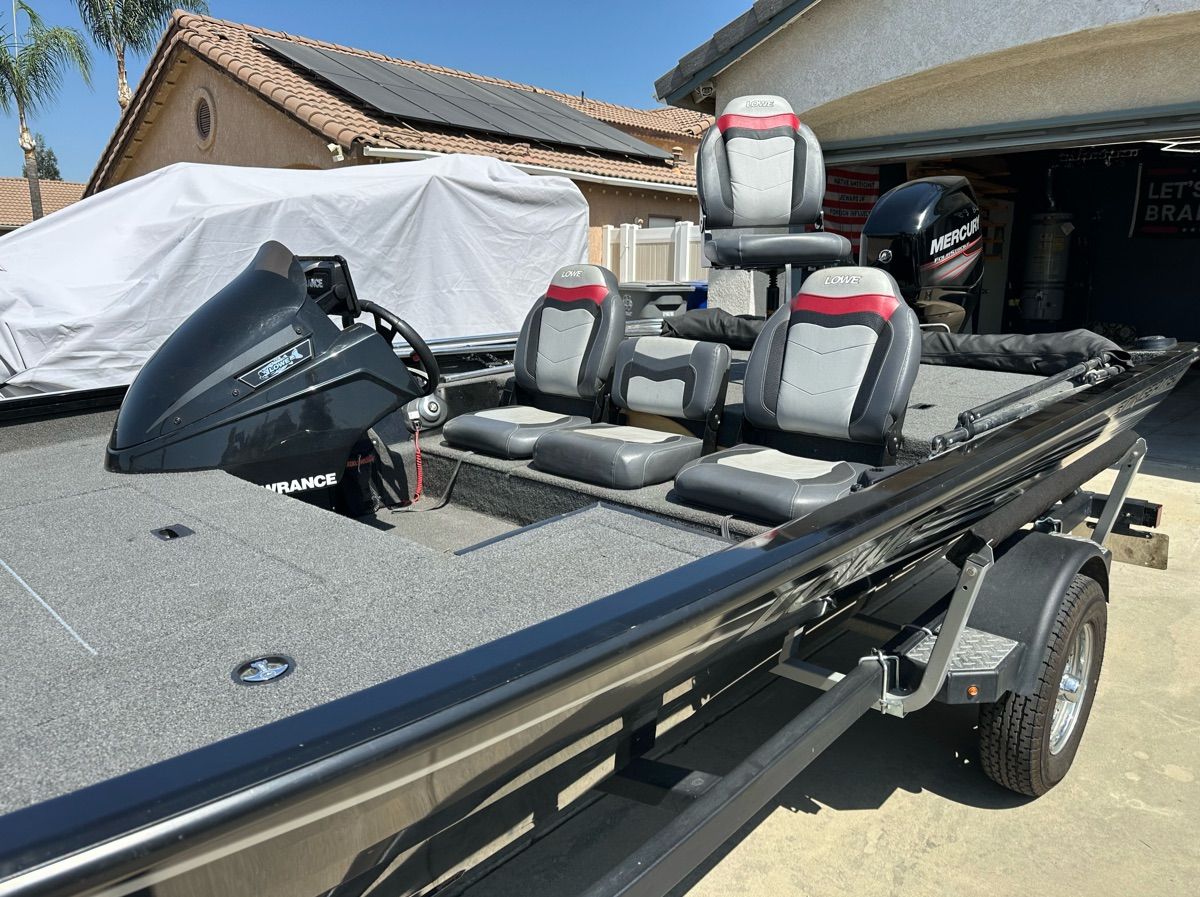 A 2018 Lowe Stinger 175C sits on a trailer in a driveway.