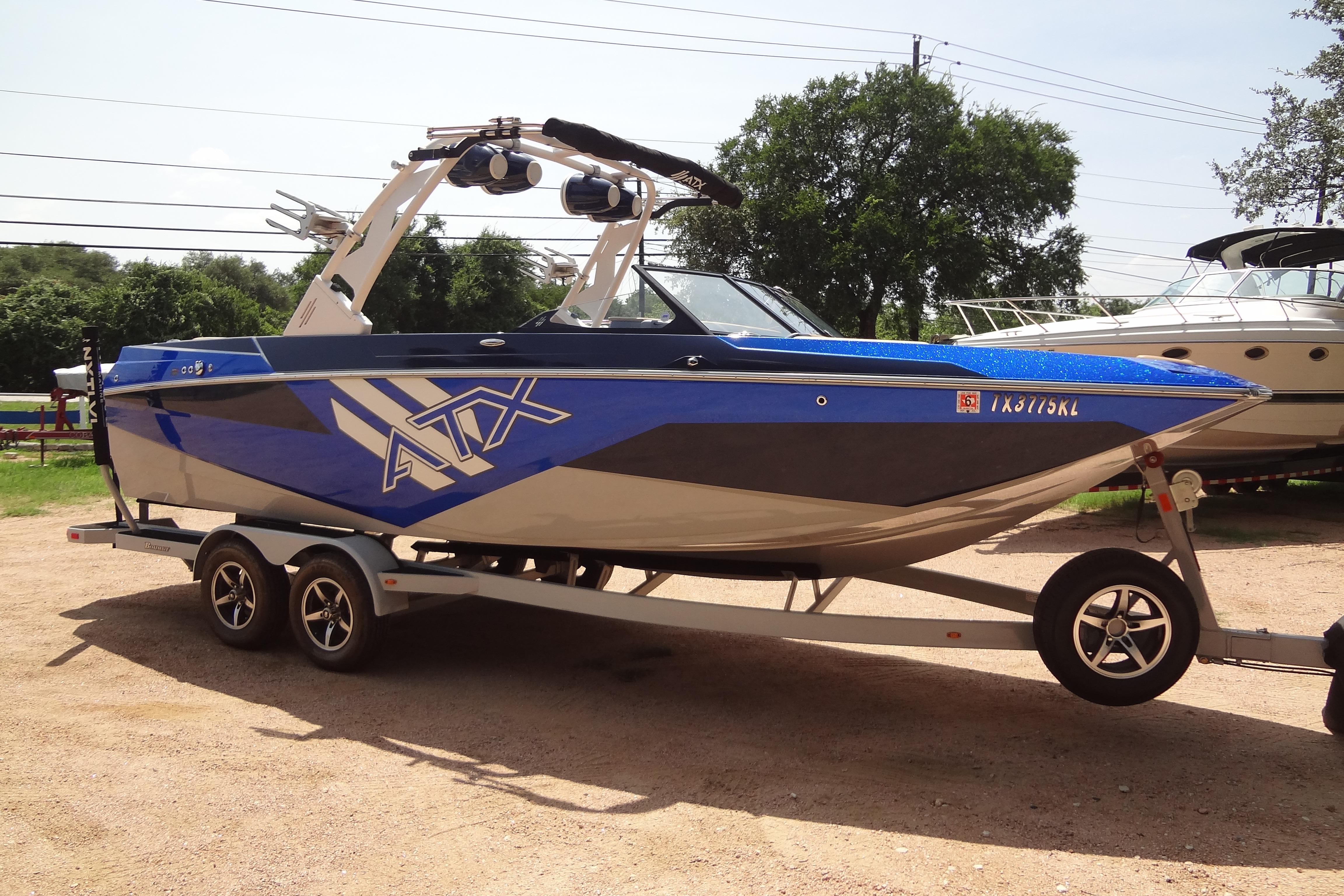 2022 ATX Surf Boats 24 Type-S on trailer, blue and gray design, parked outdoors.