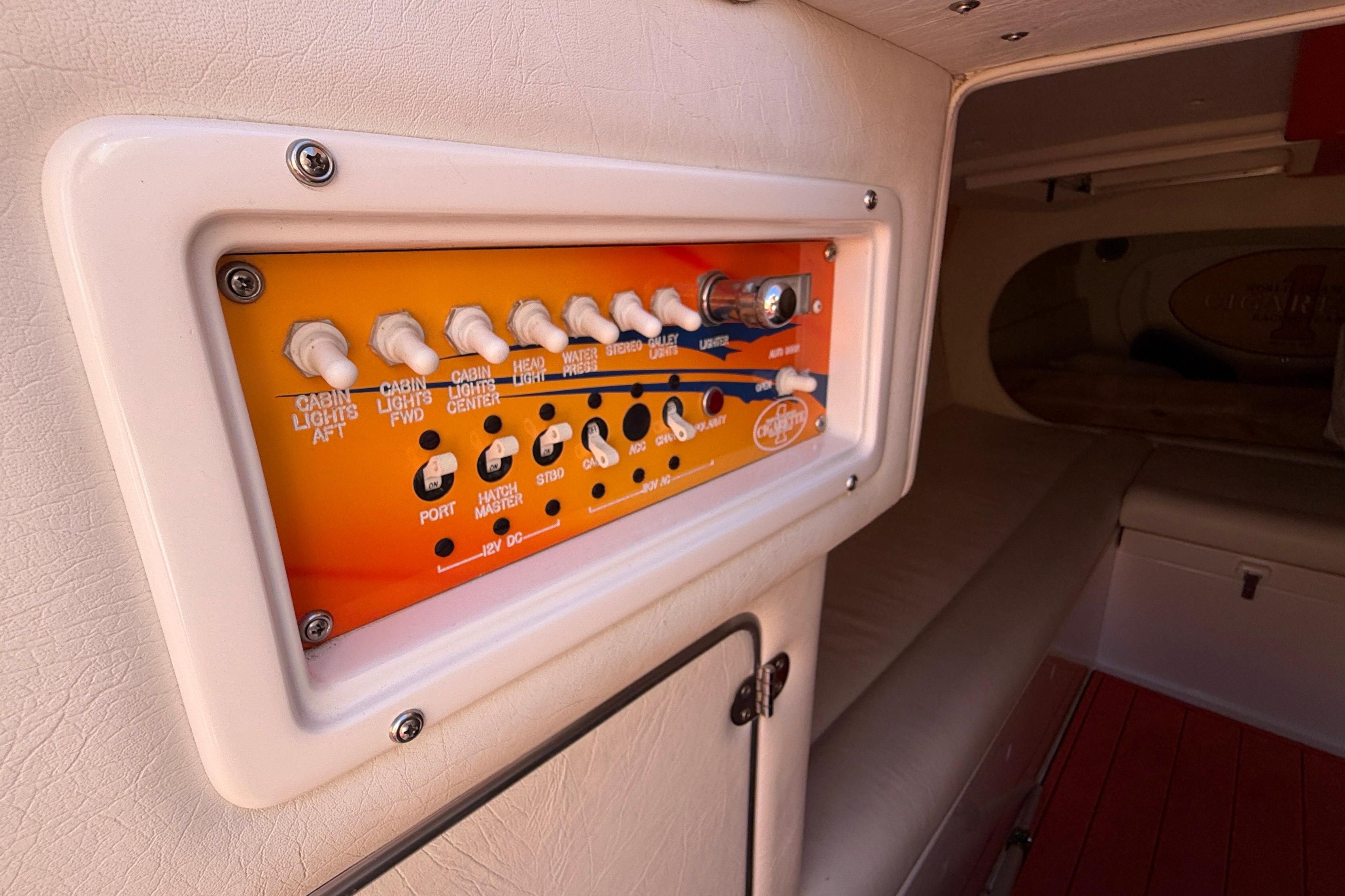 Control panel inside 2002 Cigarette 35' Cafe Racer boat cabin, featuring various switches.