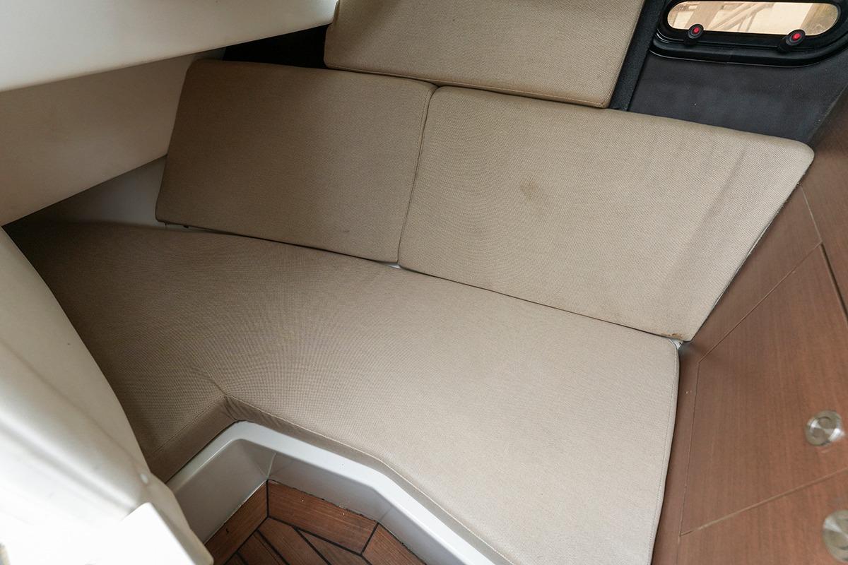 Interior cabin of 2018 Sea Ray SLX 350 with beige cushions and wooden accents.