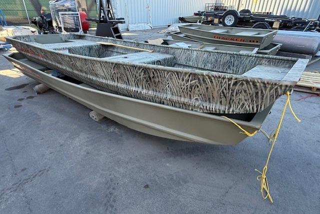 2026 Tracker Grizzly 15 Jon boat with camouflage design, parked outdoors.