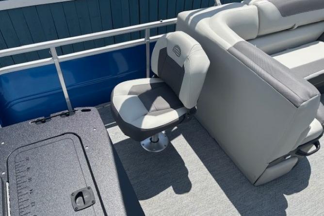 2026 Sun Tracker Fishin' Barge 20 DLX interior with swivel seat and cushioned bench.
