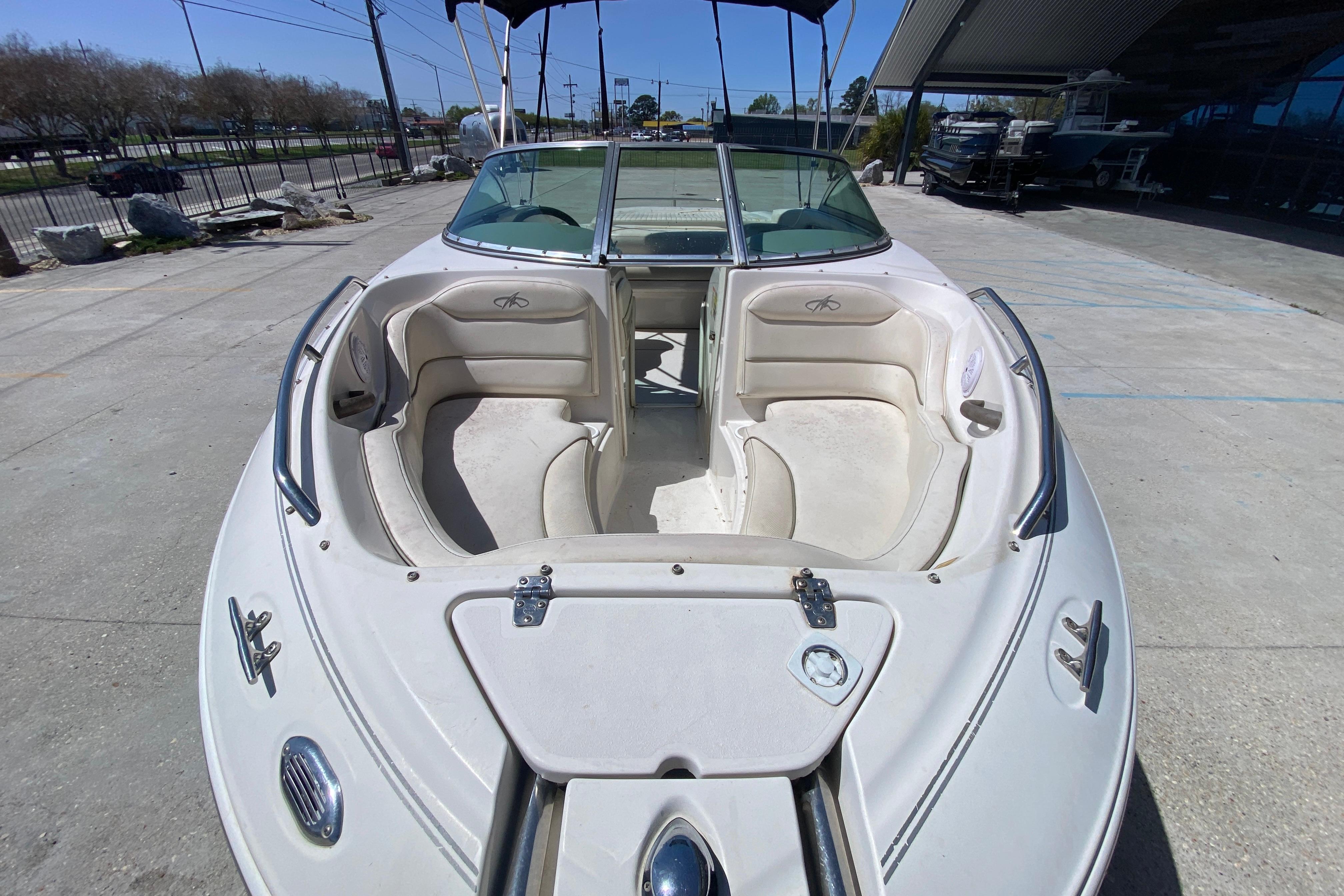 2003 Monterey 208SI Montura boat with open bow seating, parked outdoors.