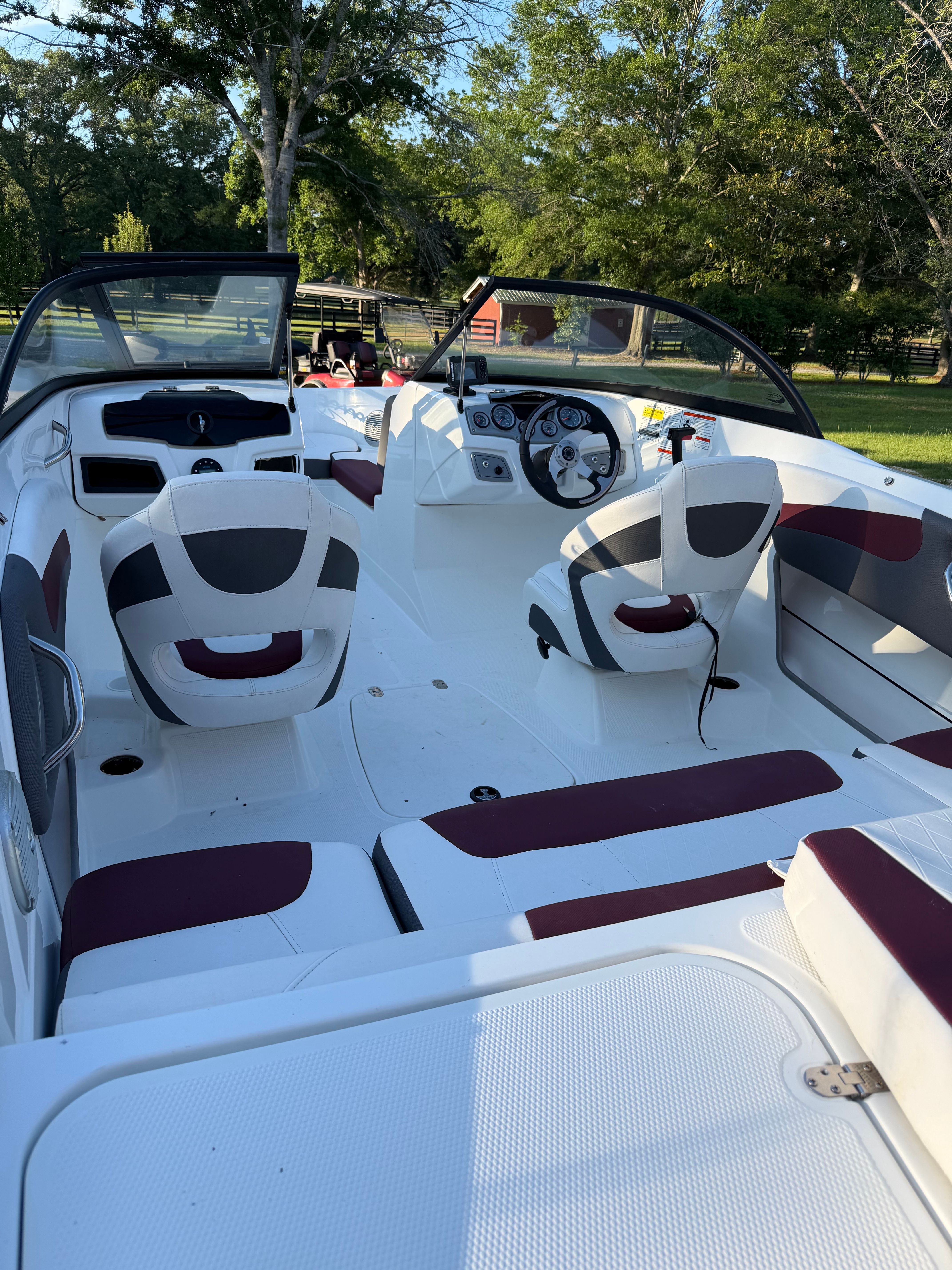 Interior of a 2020 Tracker Tahoe 550TF boat with white and red seating.