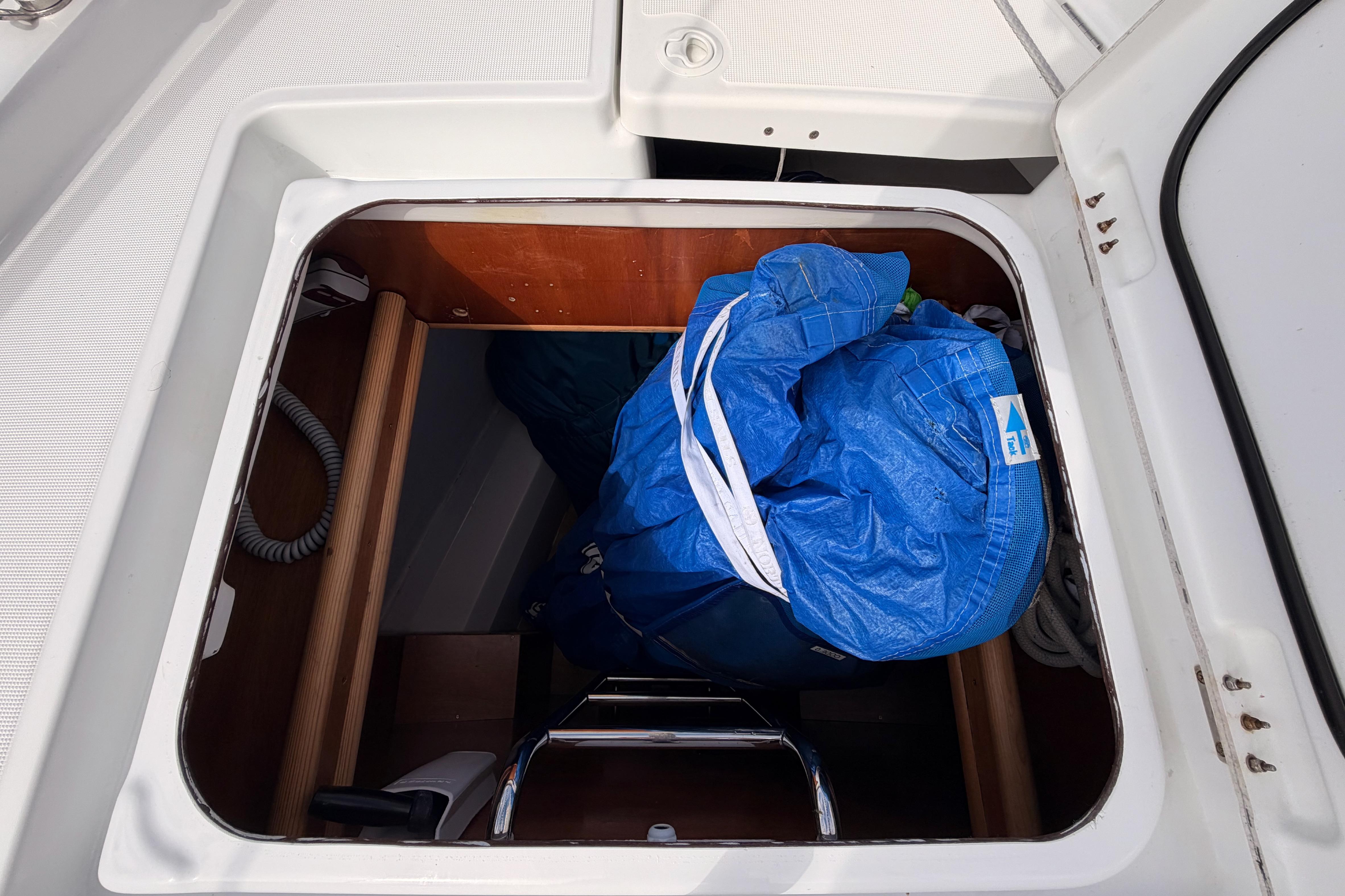 Storage compartment on a 2020 Beneteau Oceanis 46.1 sailboat with blue tarp and equipment.