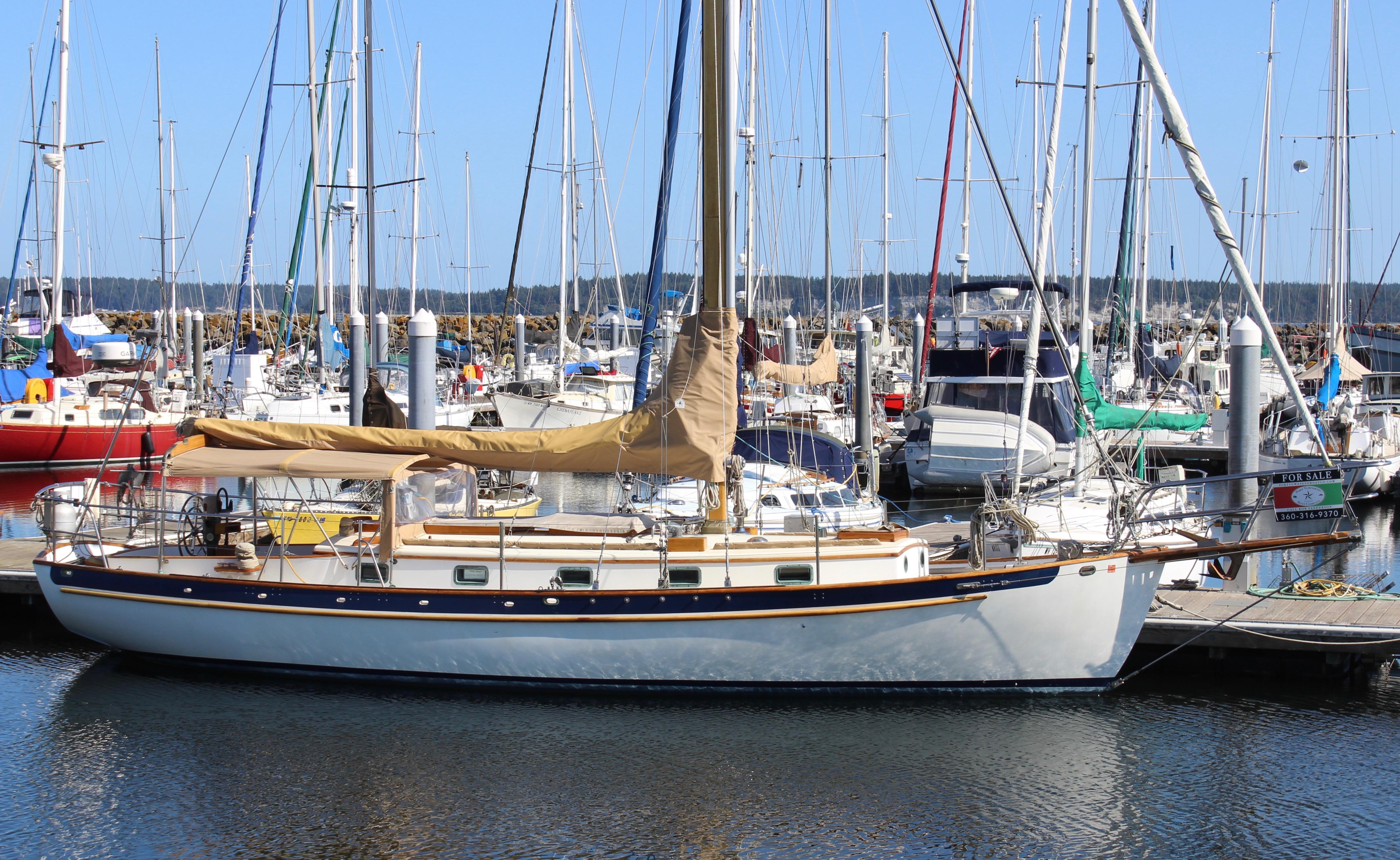 Sailboat docked in marina, Cape George 38, 1988 model, surrounded by other boats.
